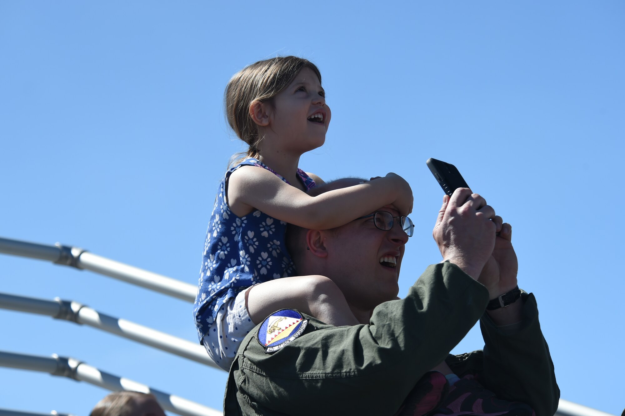 Tech. Sgt. Christopher, 42nd Attack Squadron, and his daughter enjoy a U.S. Air Force Air Demonstration Squadron Thunderbird solo pass in a display of the F-16 Fighting Falcon aircraft’s capabilities during Indian Springs Appreciation Day March 10, 2015, at Creech Air Force Base, Nevada. The team performs precision aerial maneuvers to exhibit the capabilities of modern high-performance aircraft to audiences throughout the world. (U.S. Air Force photo by Tech. Sgt. Shad Eidson/released)