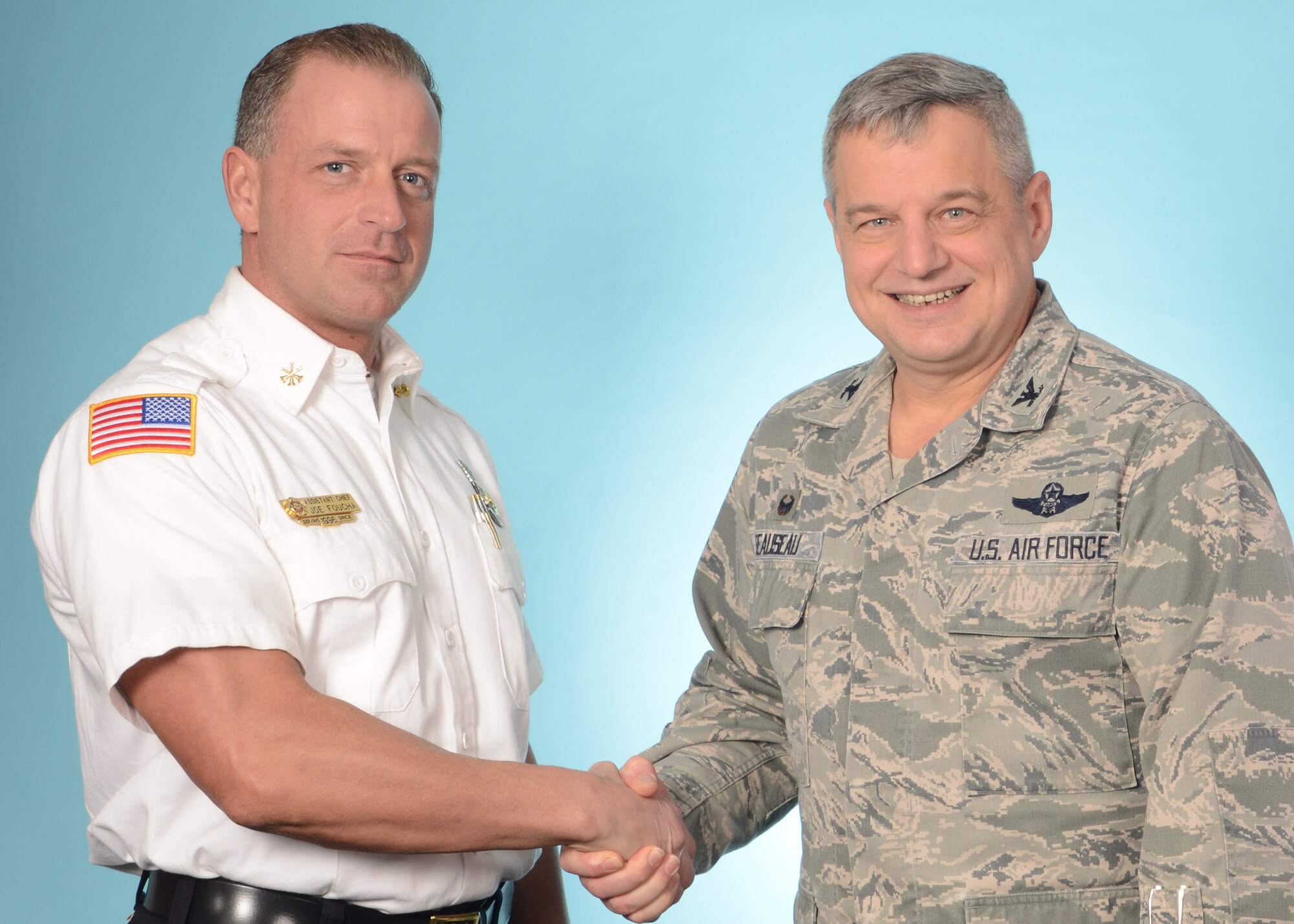 Assistant Fire Chief Joseph Foucha (left), 914th Fire Emergency Services, is congratulated on being selected the Air Force Reserve Command's Department of Defense Civilian Fire Officer of the Year by Col. Alan Teauseau, 914th Mission Support Group commander, Niagara Falls Air Reserve Station, N.Y. March 4, 2015.  (U.S. Air Force photo by Peter Borys)