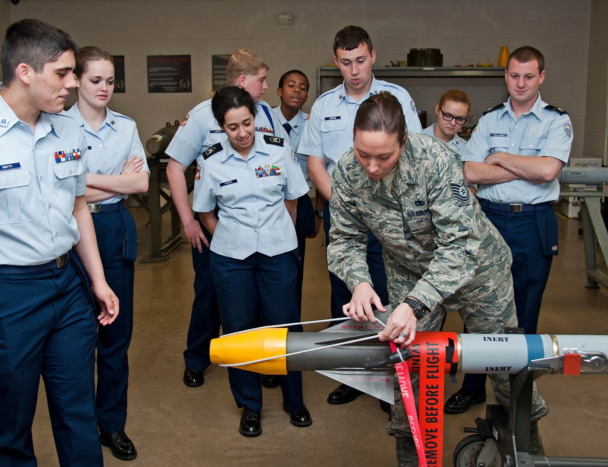 U.S. Air Force Tech. Sgt. Leeanne Phillips, 363rd Training Squadron munitions ammo instructor, removes the protective cover on an inert munition to show the warhead to the Burkburnett High School Air Force Junior ROTC cadets on Sheppard Air Force Base, Texas, March 11, 2015. The AFJROTC cadets are part of a base tour hosted by the Sheppard Air Force Base Public Affairs Department. (U.S. Air Force photo by Frank Carter/Released)