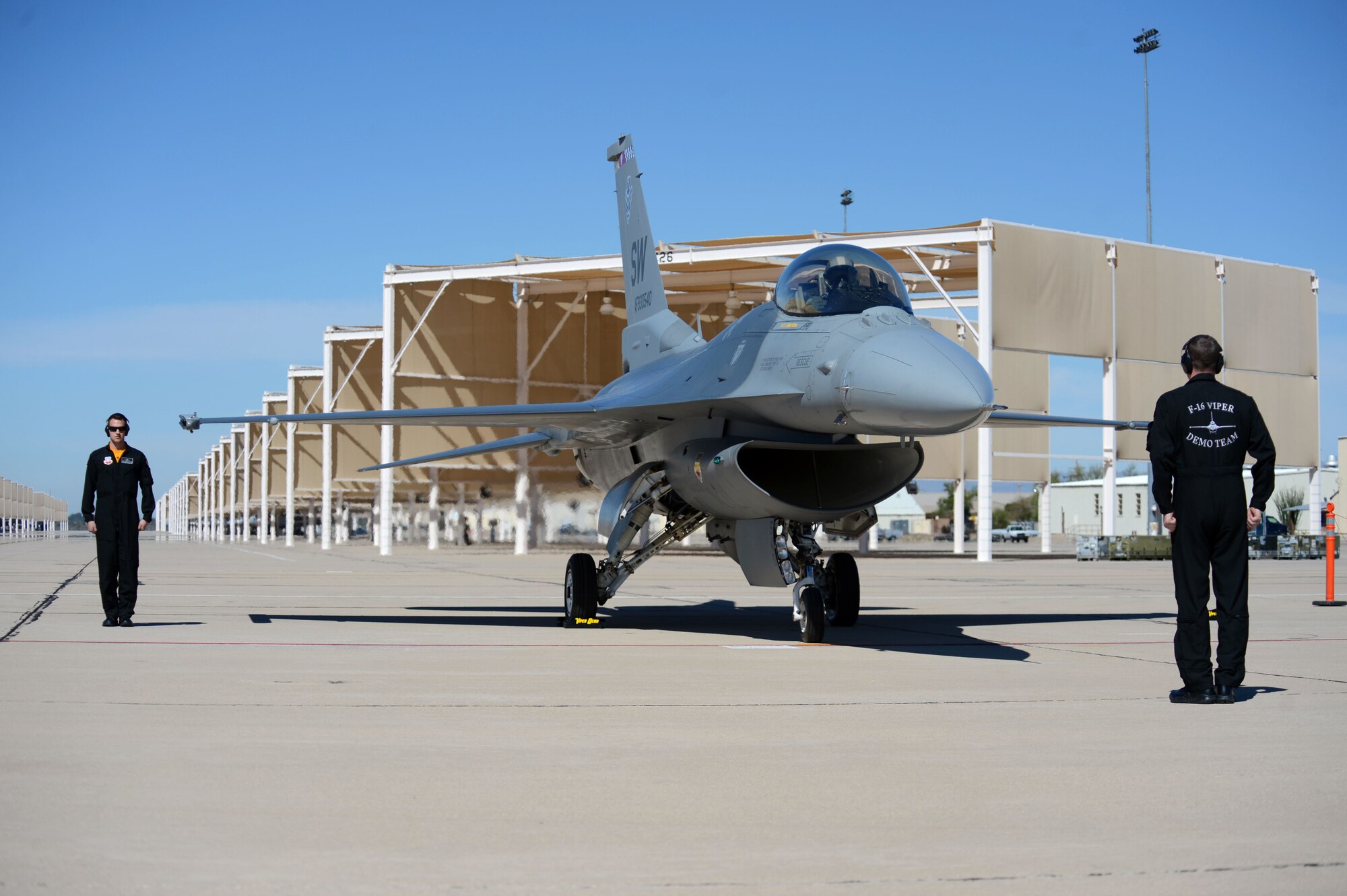 (From left) U.S. Air Force Staff Sgt.’s Keith Palaka and Joshua Tesch, F-16 Viper Demo Team crew chiefs, perform a “comout” launch for Capt. Craig Baker during the Heritage Flight Certification and Training Course at Davis-Monthan Air Force Base, Ariz., Feb. 27, 2015. During the four day course, the team launched and flew eight sorties. (U.S. Air Force photo by Senior Airman Jensen Stidham/Released)