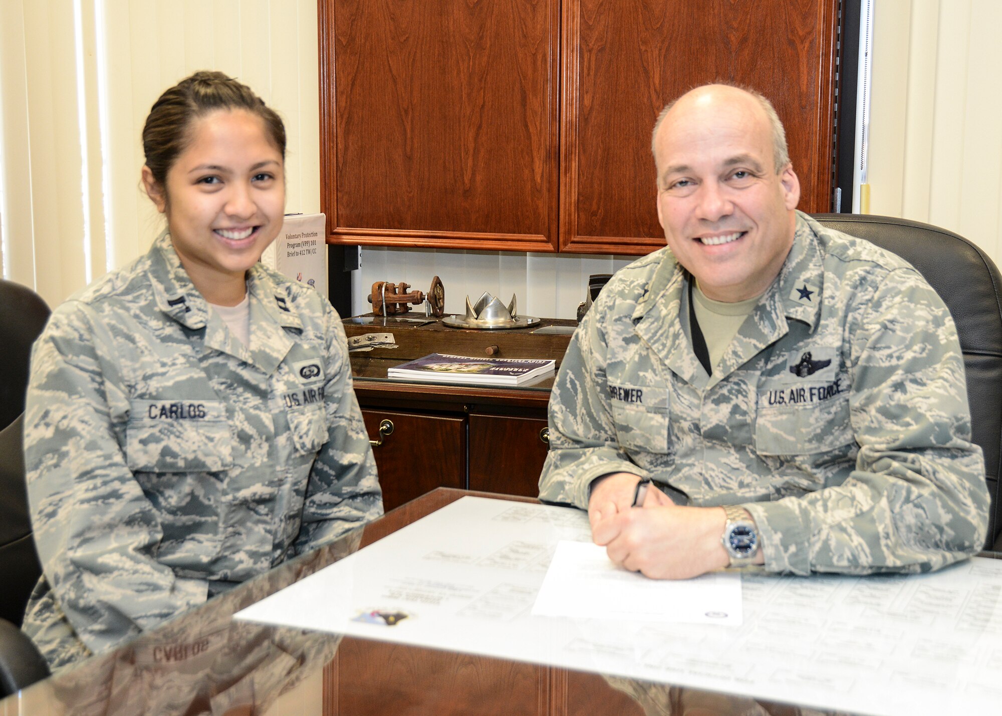 Brig. Gen. Michael T. Brewer, 412th Test Wing commander, signs the Edwards AFB Air Force Assistance Fund letter officially starting the campaign along with AFAF program manager Capt. Claire Carlos. (U.S. Air Force photo by Kenji Thuloweit)