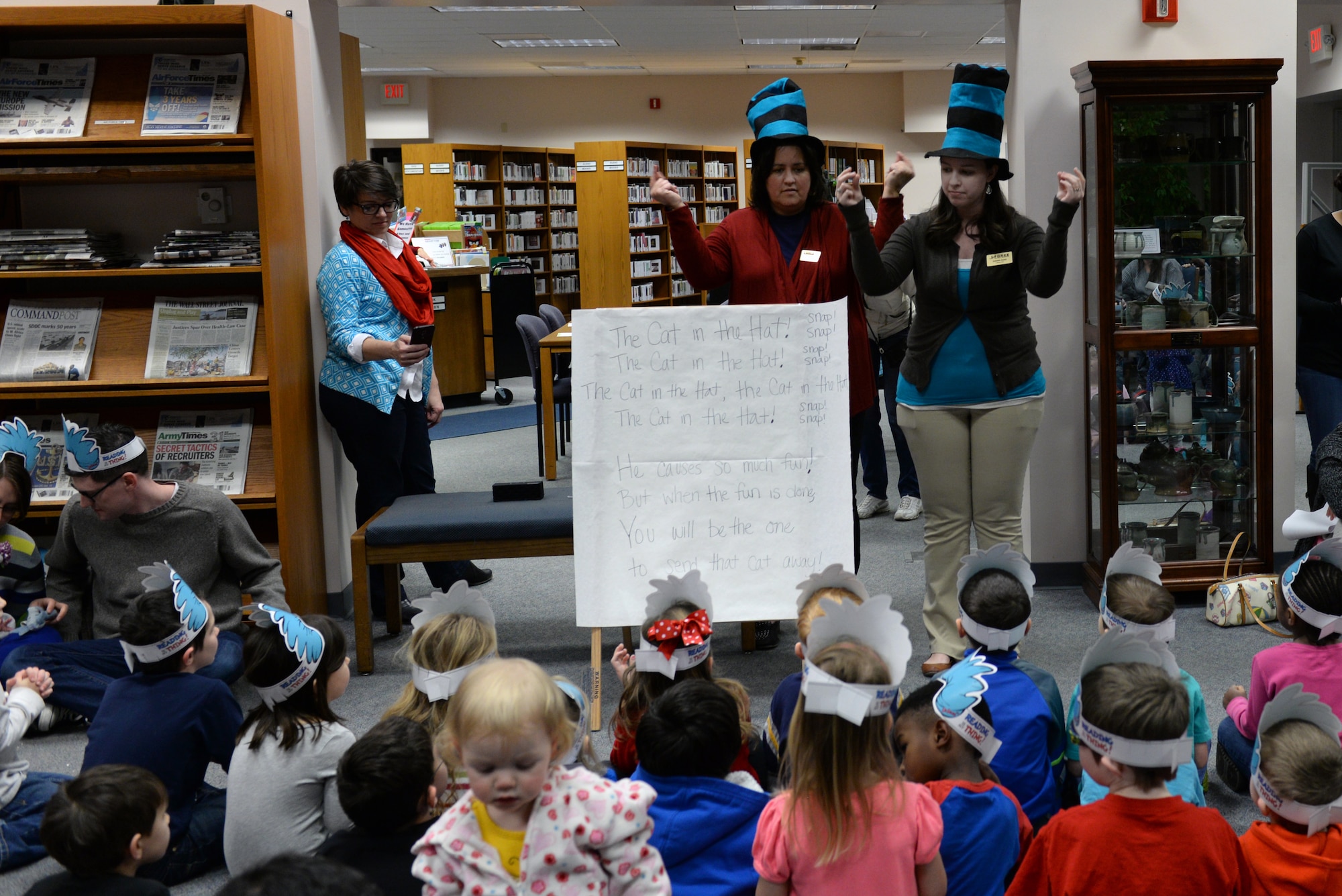 Donna Panger and Amanda James lead children in a song about "The Cat in the Hat," a Dr. Seuss character, during a birthday party held in his honor at the library at Scott Air Force Base, Illinois on March 5, 2015. The birthday party started with a sing-along and story time. Panger is a library technician and James is a library aide at the 375th Force Support Squadron library. (U.S. Air Force photo by Senior Airman Sarah Hall-Kirchner/Released)