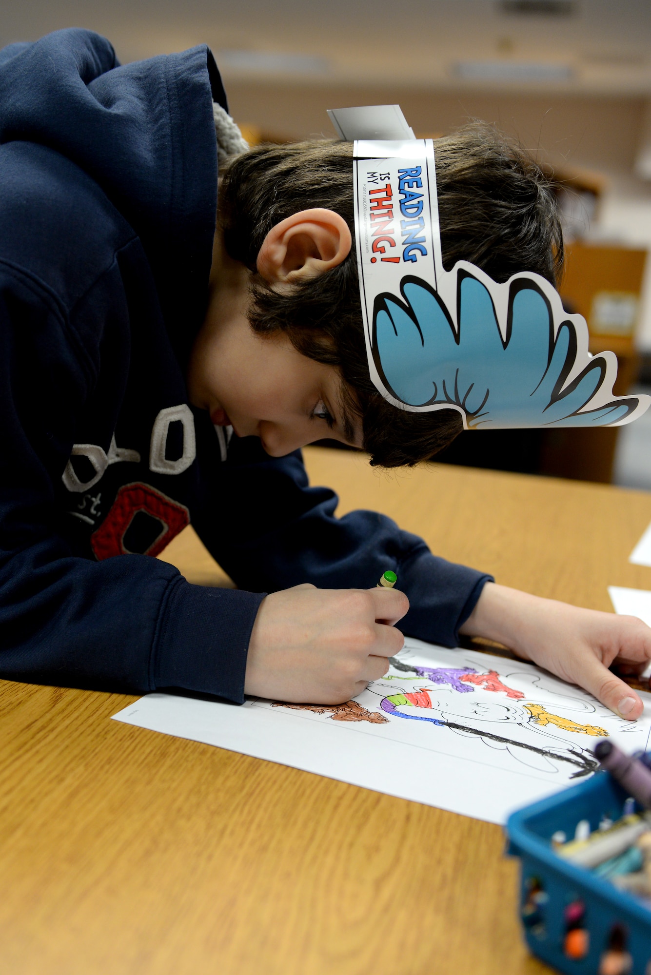 Diego Esguerra, 9, colors a Dr. Seuss cartoon during a birthday party held in honor of him at the library at Scott Air Force Base, Illinois on March 5, 2015. Diego said he likes Dr. Seuss's unlimited imagination. (U.S. Air Force photo by Senior Airman Sarah Hall-Kirchner/Released)