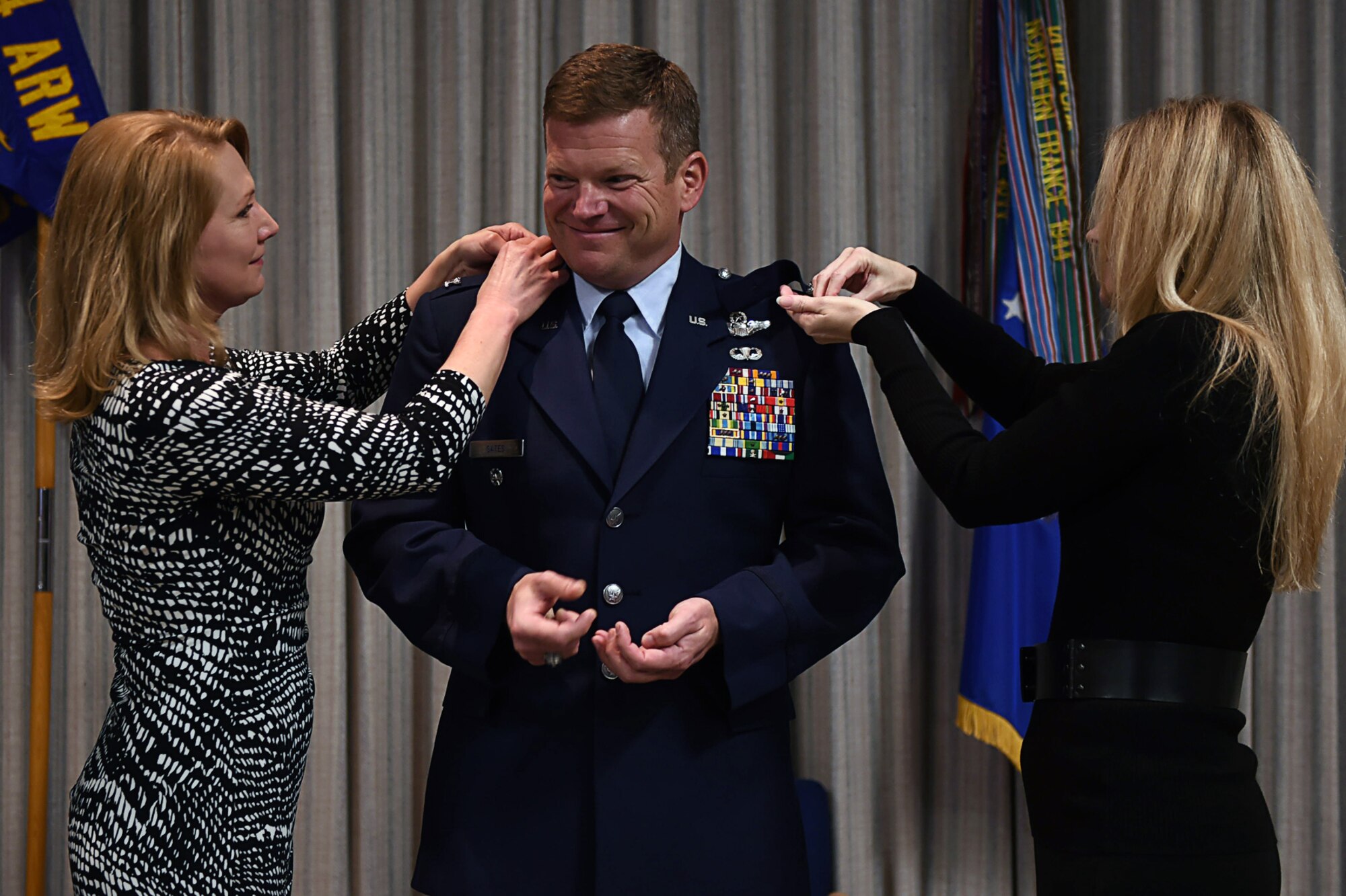 Col. Hiram P. Gates III, 434th Air Refueling Wing vice commander, has his wife Ann Gates, left, and his sister Caryan Dearing, right, pin eagle rank insignias on his service dress coat during a pin-on ceremony at Grissom Air Reserve Base, Ind., Feb.7, 2015. Gates was joined by friends and family to witness his pin-on ceremony which history dates back centuries. (U.S. Air Force photo/Senior Airman Andrew Crawford)