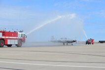 Lt. Col. Bryan Nalley, 96th Flying Training Squadron director of operations, passes under a water arch on his final flight in the T-6 Texan II on Laughlin Air Force Base, Texas, March 6, 2015. Military aviators have a tradition where aircrew members, upon completion of their final flight, or "fini-flight", are met and hosed down with water by their fellow airmen, family and friends. It's assumed that the tradition of the fini-flight originated from the U.S. Army Air Force days of World War II and was designed to accompany milestones in the career of the entire aircrew, respected individuals of rank or repute, or a commander's departure to another command or retirement. (U.S. Air Force photo by 2nd Lt. Aaron Redfield)(Released)