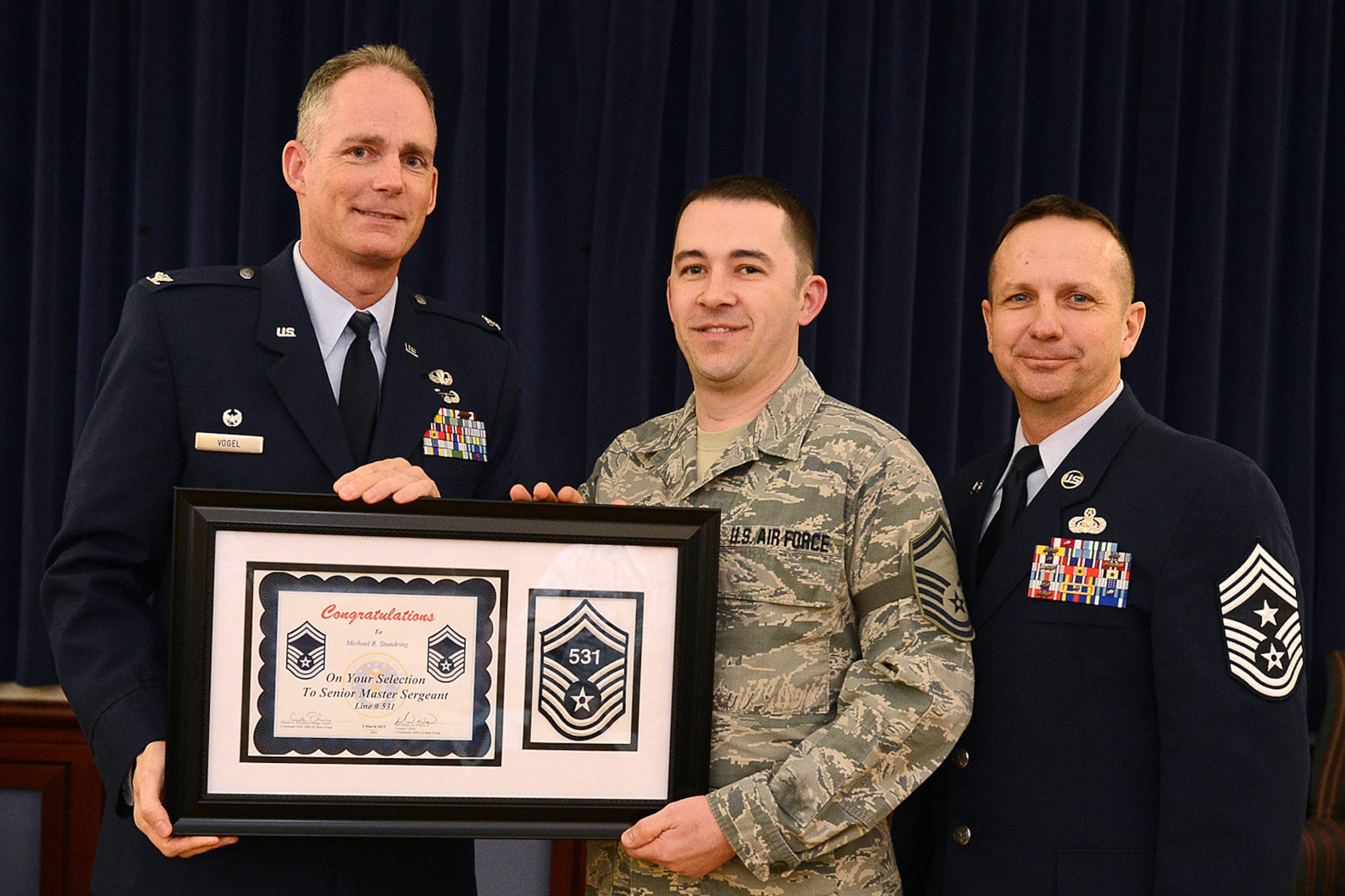 Col. Michael A. Vogel, 66th Air Base Group commander, and Hanscom Command Chief Master Sgt. Craig Poling, pose with Master Sgt. Michael Standring, 66th Medical Squadron Aerospace and Operational Medicine flight chief, for a photo during the E-8 selection ceremony at the Minuteman Commons March 5. Three Hanscom master sergeants were selected. Air Force officials selected 1,257 of 14,362 eligible master sergeants for promotion to senior master sergeant, a rate of 8.75 percent. (U.S. Air Force photo by Jerry Saslav)