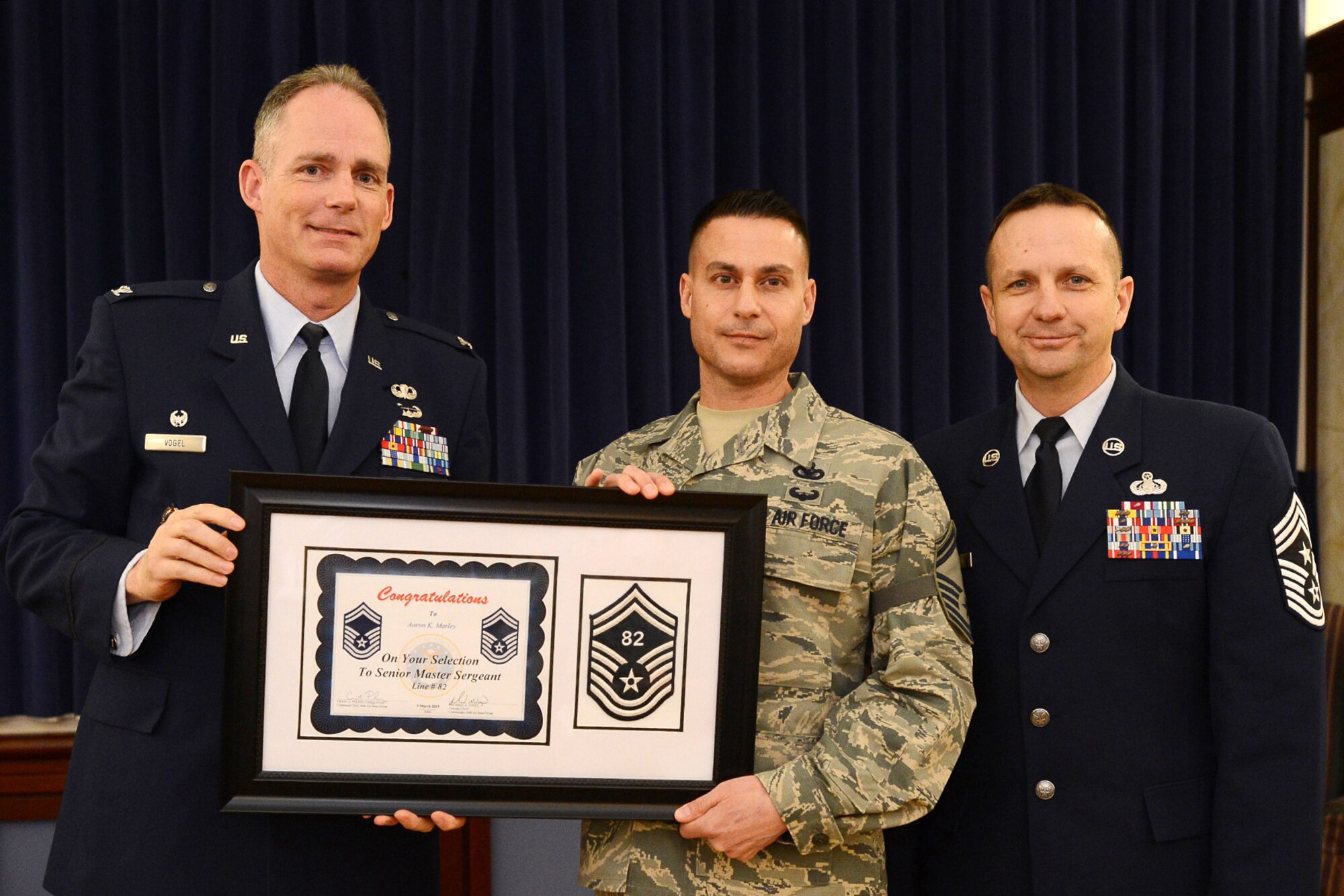 66th Air Base Group Commander Col. Michael A. Vogel and Hanscom Command Chief Master Sgt. Craig Poling stand beside Master Sgt. Aaron Marley, 66th Force Support Squadron Patriot Honor Guard superintendent, for a photo during an E-8 selection ceremony at the Minuteman Commons March 5. Air Force officials selected 1,257 of 14,362 eligible master sergeants for promotion to senior master sergeant, a rate of 8.75 percent. Three Hanscom master sergeants were selected. (U.S. Air Force photo by Jerry Saslav)