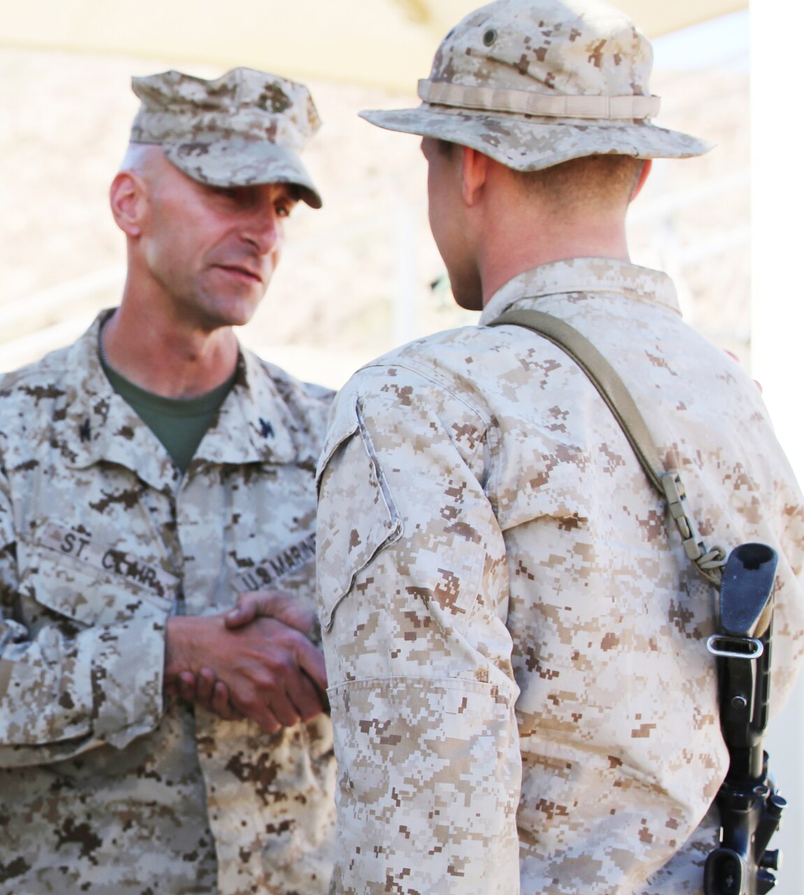 Marine Corps Col. Matthew G. St. Clair, commanding officer of Ground Combat Element Integrated Task Force, left, presents Marine Corps Lance Cpl. Nicholas J. Cascone, amphibious assault vehicle crewman, with a Navy and Marine Corps Achievement Medal. U.S. Marine Corps photo by Cpl. Paul S. Martinez