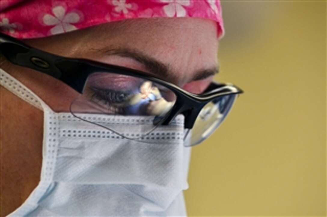 U.S. Air Force Maj. Alicia Capps assists with a minor surgery on Aviano Air Base, Italy, March 4, 2015. Capps is a 31st Surgical Operations Squadron physician’s assistant.