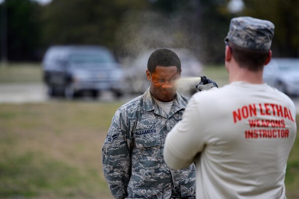 Airman 1st Class DeAaron Alexander receives a level-one contamination of oleoresin capsicum from Senior Airman Daniel Miller Feb. 27, 2015, on Laughlin Air Force Base, Texas. A required certification for all security forces personnel, level-one training consists of spraying an individual from ear to ear, across the brow while eyes are closed, with a half second to one second spray from an OC canister, 36 inches from the subject's face. The individual must then open their eyes, complete the five assessment stations and make it to the decontamination point on their own. Both Airmen are members of the 47th Security Forces Squadron. Alexander is a patrolman and Miller is a non-lethal weapons instructor. (U.S. Air Force photo/Tech. Sgt. Steven R. Doty)