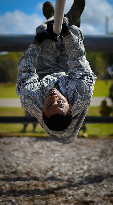 Tech. Sgt. Eric Dagin pulls himself across a rope obstacle March 3, 2015, at the Hillsborough County Sheriff’s Office firearms training center in Lithia, Fla. Dagin is a Joint Communications Support Element (JCSE) cyber transport craftsman. Members of the JCSE completed the obstacle course before the stress fire portion of Warrior Spirit ’15. (U.S. Air Force photo/Tech. Sgt. Brandon Shapiro)