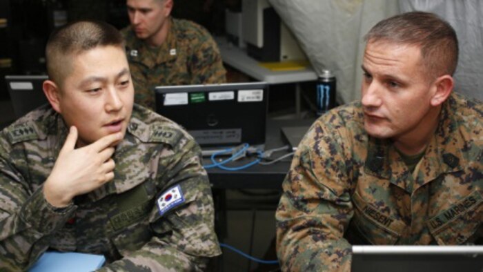 U.S. Marine Corps Master Sgt. Brannon Niesent, Fort Collins, Colorado, III Marine Expeditionary Force Command Element G-3 Force Protection officer, works with Republic of Korea (ROK) Marine Capt. Jae Eun Lee, Marine Corps Headquarters FRAGO officer, during Exercise Key Resolve 15 on Camp Mujuk, South Korea, March 10, 2015. Key Resolve is held annually to strengthen ROK-U.S. combat readiness and joint interoperability.