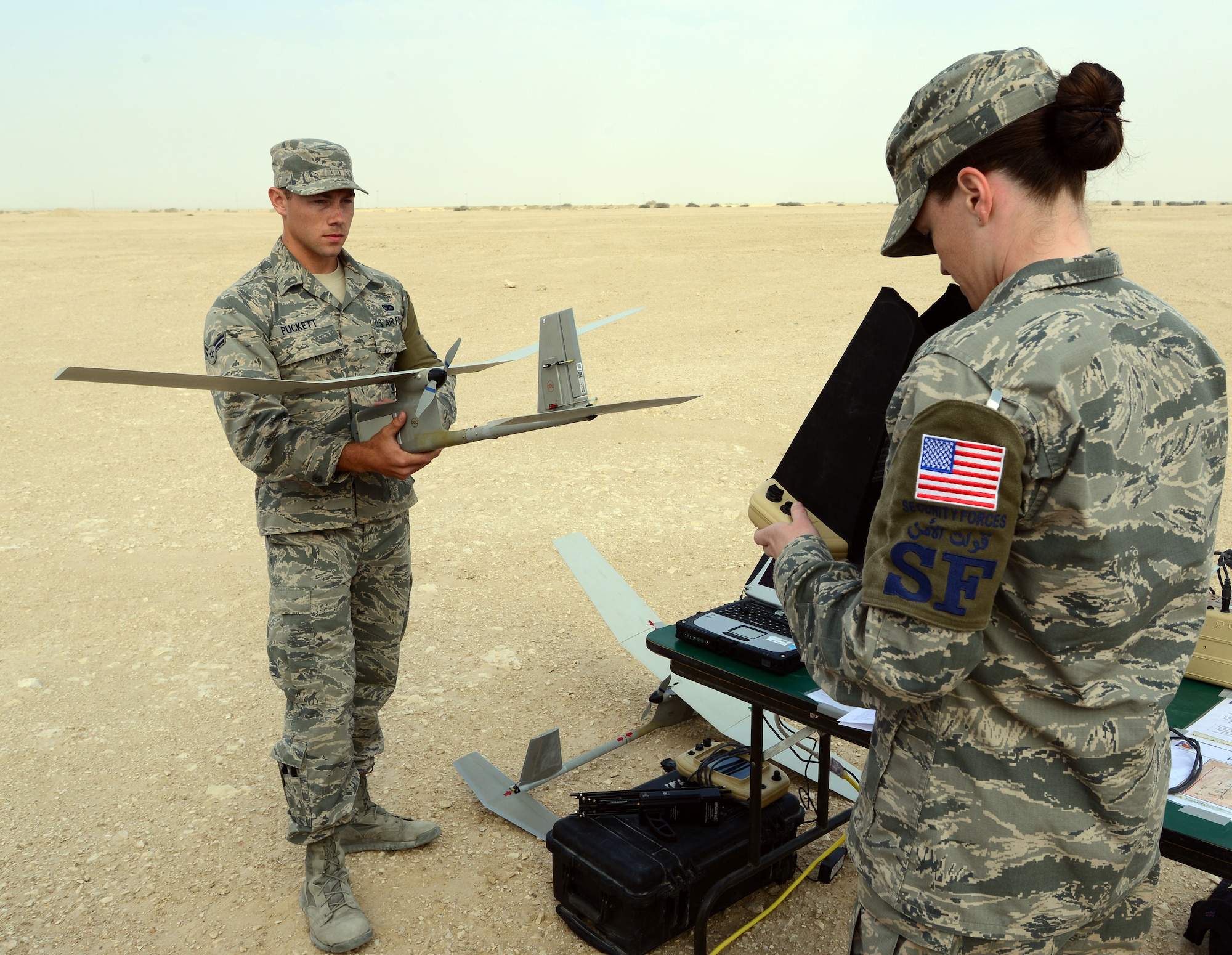 Airman Michael Puckett (left) and SSgt Elizabeth Henderson, 379th Expeditionary Security Forces Squadron, conduct pre-flight checks for an R-11B Raven at Al Udeid Air Base, Qatar, Mar 4, 2015, before an aerial demonstration for senior Qatari Air Force and 379th Air Expeditionary Wing leaders.  The RQ-11 Raven is a lightweight unmanned aircraft system that’s designed for rapid deployment and high-mobility for military operations. At Al Udeid, security forces Airmen use the Raven to support anti-terrorism measures like day or night aerial intelligence, surveillance, target acquisition, and reconnaissance. This is the first time since 2005 that the Raven has been used at Al Udeid. (Air Force photo by Master Sgt. Kerry Jackson) 