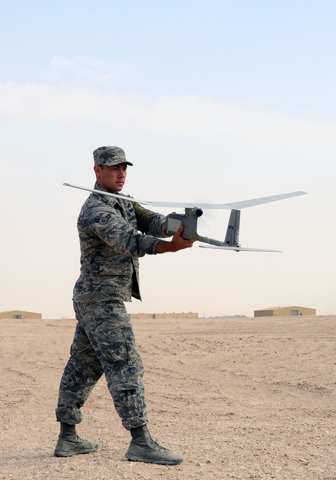Airman Michael Puckett, 379th Expeditionary Security Forces Squadron, launches an R-11B Raven into the “wild blue yonder” during a demonstration for senior Qatari Air Force and 379th Air Expeditionary Wing leaders, Mar 4, 2015, at Al Udeid Air Base, Qatar.  The RQ-11 Raven is a lightweight unmanned aircraft system that’s designed for rapid deployment and high-mobility for military operations. At Al Udeid, security forces Airmen use the Raven to support anti-terrorism measures like day or night aerial intelligence, surveillance, target acquisition, and reconnaissance. This is the first time since 2005 that the Raven has been used at Al Udeid. (Air Force photo by Master Sgt. Kerry Jackson) 