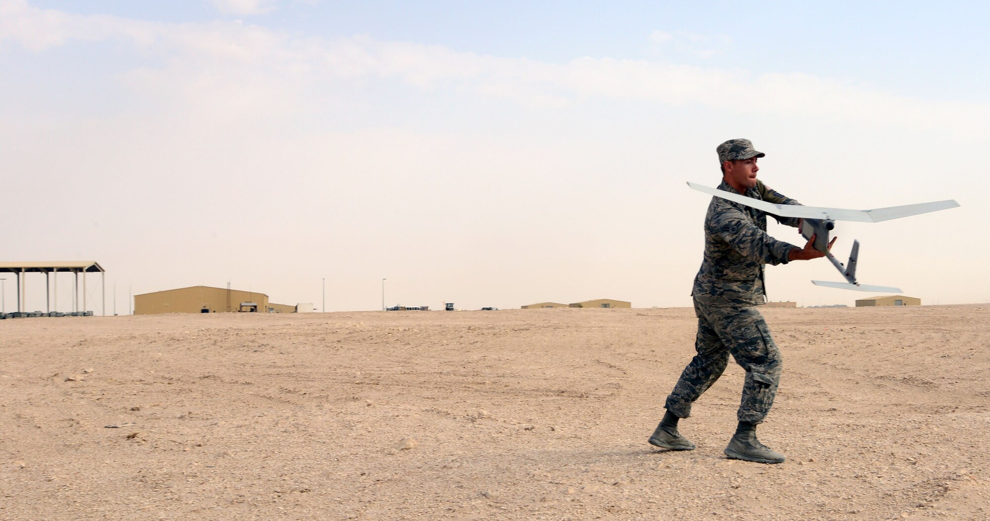 Airman Michael Puckett, 379th Expeditionary Security Forces Squadron, launches an R-11B Raven Small into the “wild blue yonder” during a demonstration for senior Qatari Air Force and 379th Air Expeditionary Wing leaders, Mar 4, 2015, at Al Udeid Air Base, Qatar. The RQ-11 Raven is a lightweight unmanned aircraft system that’s designed for rapid deployment and high-mobility for military operations. At Al Udeid, security forces Airmen use the Raven to support anti-terrorism measures like day or night aerial intelligence, surveillance, target acquisition, and reconnaissance. This is the first time since 2005 that the Raven has been used at Al Udeid. (Air Force photo by Master Sgt. Kerry Jackson) 