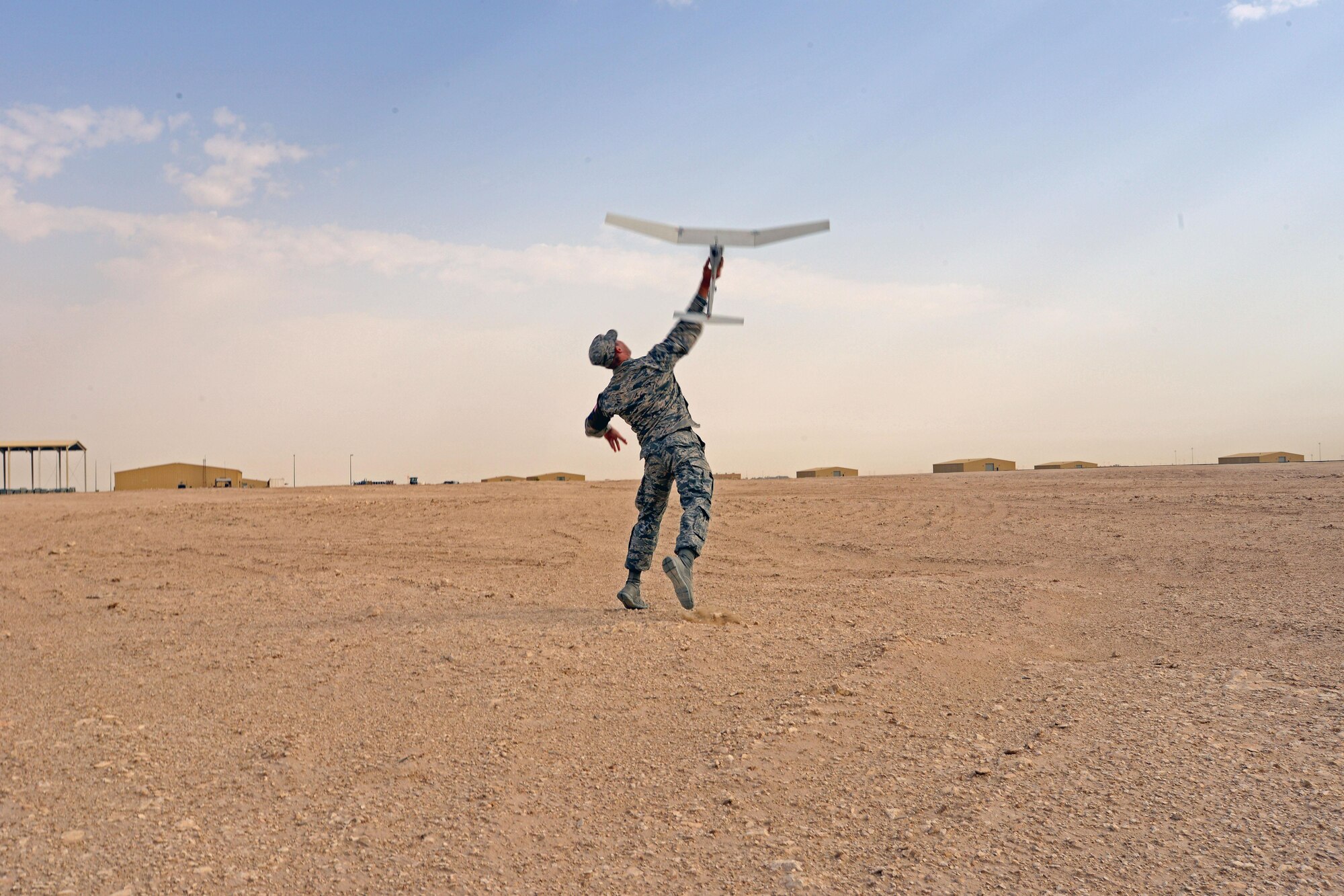 Airman Michael Puckett, 379th Expeditionary Security Forces Squadron, launches an R-11B Raven Small into the “wild blue yonder” during a demonstration for senior Qatari Air Force and 379th Air Expeditionary Wing leaders, Mar 4, 2015, at Al Udeid Air Base, Qatar.  The RQ-11 Raven is a lightweight unmanned aircraft system that’s designed for rapid deployment and high-mobility for military operations. At Al Udeid, security forces Airmen use the Raven to support anti-terrorism measures like day or night aerial intelligence, surveillance, target acquisition, and reconnaissance. This is the first time since 2005 that the Raven has been used at Al Udeid. (Air Force photo by Master Sgt. Kerry Jackson)
