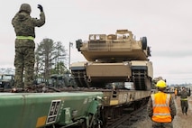 Marines with 2nd Tank Battalion, 2nd Marine Division, and Combat Logistics Battalion 2, Combat Logistics Regiment 2, 2nd Marine Logistics Group, guide an M1A1 Abrams Tank onto a railcar during a railhead operation aboard Camp Lejeune, N.C., Feb. 17, 2015. During the railhead operation, 2nd Tanks was in charge of bringing the gear to the railroad and loading onto the railcars. Landing support specialists were in charge of safety, supervising and tracking the equipment as it was loaded. (U.S. Marine Corps photo by Cpl. James R. Smith/Released)