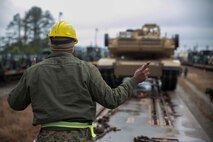A Marine with 2nd Tank Battalion, 2nd Marine Division, guides a tank onto a railcar during a railhead operation aboard Camp Lejeune, N.C., Feb. 17, 2015. Landing support specialists with Combat Logistics Battalion 2, Combat Logistics Regiment 2, 2nd Marine Logistics Group, were in charge of safety, supervising and tracking the equipment as it was loaded. (U.S. Marine Corps photo by Cpl. James R. Smith/Released)