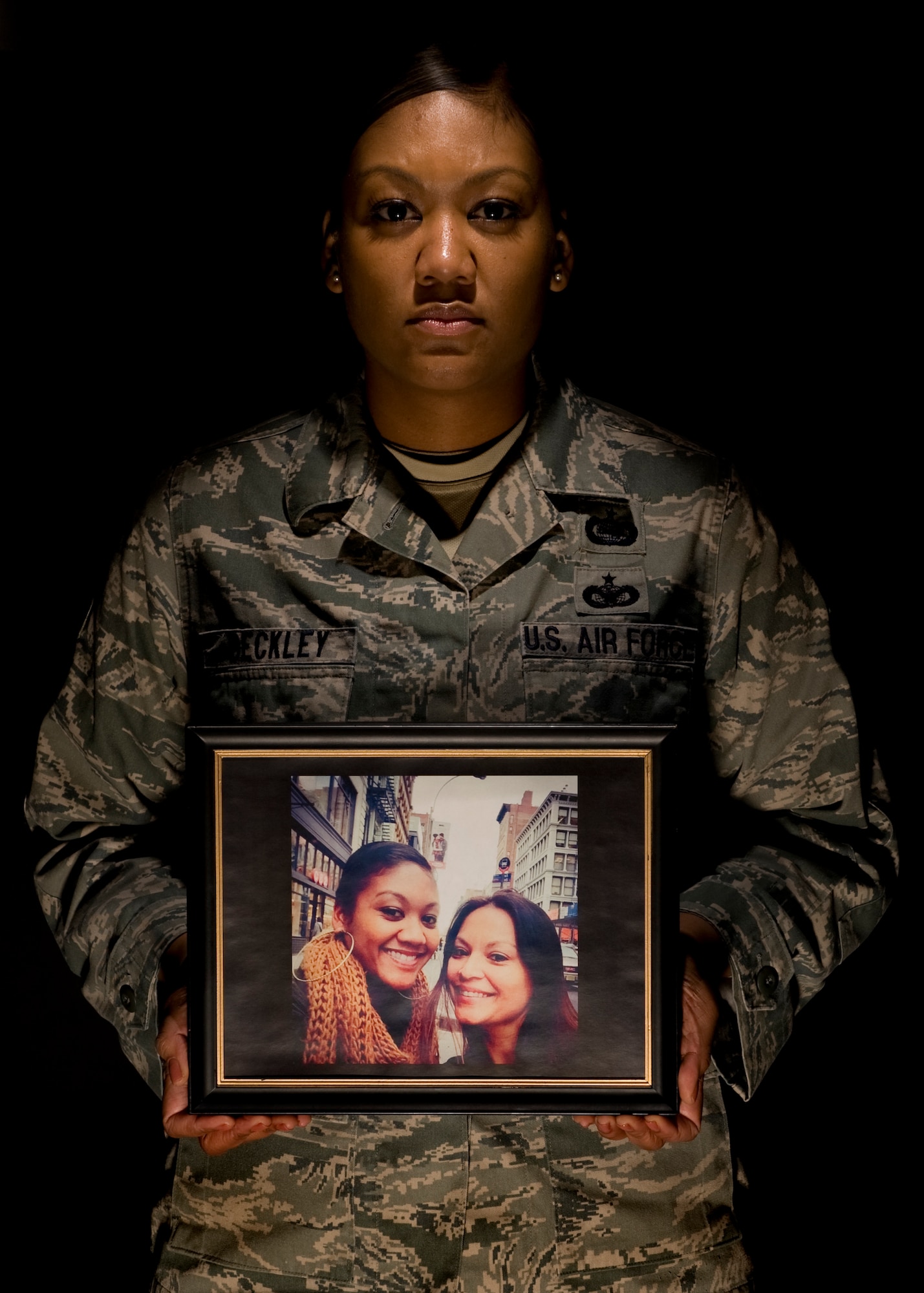 Tech. Sgt. Shamika Beckley poses with a photo of her and her sister, Raquel Calleja, Mar. 4, 2015, at Dover Air Force Base, Del. Beckley’s sister was killed by a drunk driver Dec. 22, 2014, in Long Island, N.Y. Beckley was able to have some of her travel costs, associated with the tragedy, reimbursed by the Air Force Aid Society emergency travel provision that is financed by the Air Force Assistance Fund. Beckley is the 436th Operations Support Squadron NCO in charge unit intelligence. (U.S. Air Force photo/Airman 1st Class William Johnson)