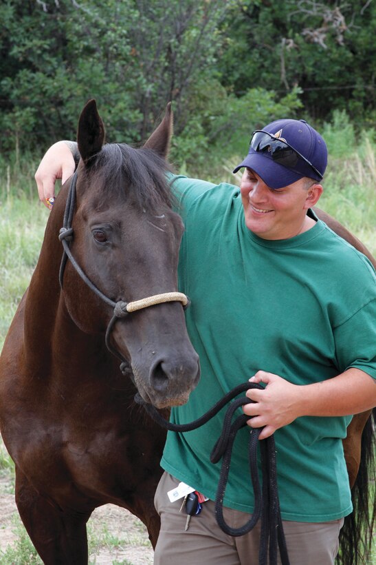 Army veteran and wounded warrior Jacob Legendre poses with Academy-owned horse Stormin Wheat in 2011. Legendre said the Academy's Warrior Wellness program brought him hope and allowed him to focus on reasons to keep moving forward. (U.S. Air Force photo/Andrea Caudill) 