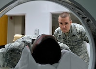 Senior Airman David Pegg, 56th Medical Support Squadron lead cat scan technician, watches as Tech Sgt. Erik Walker, 56th Medical Support Squadron assistance NCOIC of ultrasound, goes into the scanner during a training session at Luke Air Force Base, Arizona, March 3, 2015. CT scans are used to locate abnormalities in the head, chest and abdomen. (U.S. Air Force photo by Senior Airman Devante Williams)