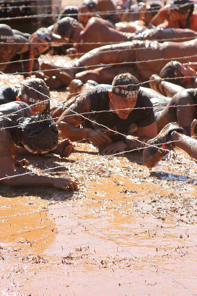 Captain Matthew Mallalieu, the executive officer with Marine Corps Recruiting Station Atlanta, 6th Marine Corps District crawls through a pit of mud under concertina wire as part of the Spartan Race Atlanta Sprint. Held March 09, 2015 at the Georgia International Horse Park in Conyers, Ga., the race consisted of 26 grueling obstacles spanning a total of 4.5 miles of alpine terrain. “The race was challenging but fun,” said Mallalieu. “Each obstacle had its own degree of difficulty, but that’s what keeps it interesting and pushes everyone to finish, and I’m looking forward to the next one.”