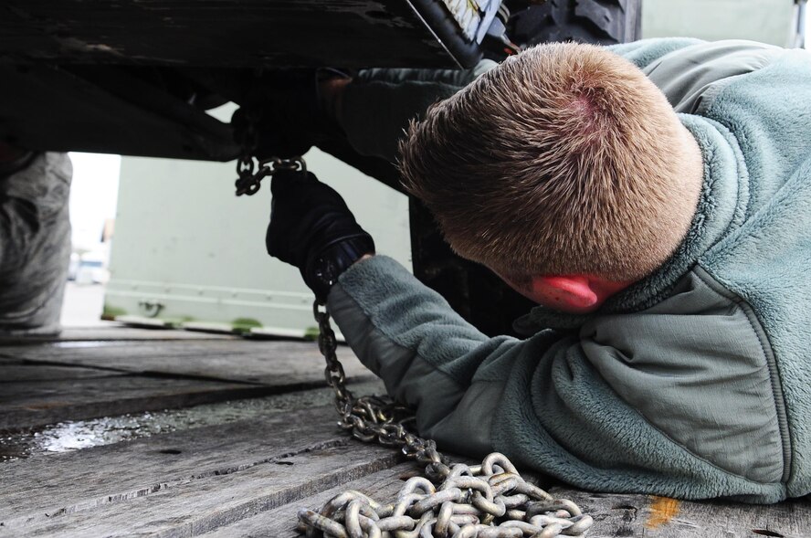 Senior Airman Tristan Roberts, 1st Special Operations Logistics Readiness Squadron vehicle operations, secures a vehicle to a trailer at Hurlburt Field, Fla., Feb 24, 2015. Vehicle Operations Flight provides transportation services on demand for Hurlburt Field to include Distinguished Visitor support, base taxi, flight line operations and cargo pick-up and delivery services, and government driver's license issue. (U.S. Air Force photo/Airman 1st Class Andrea Posey)