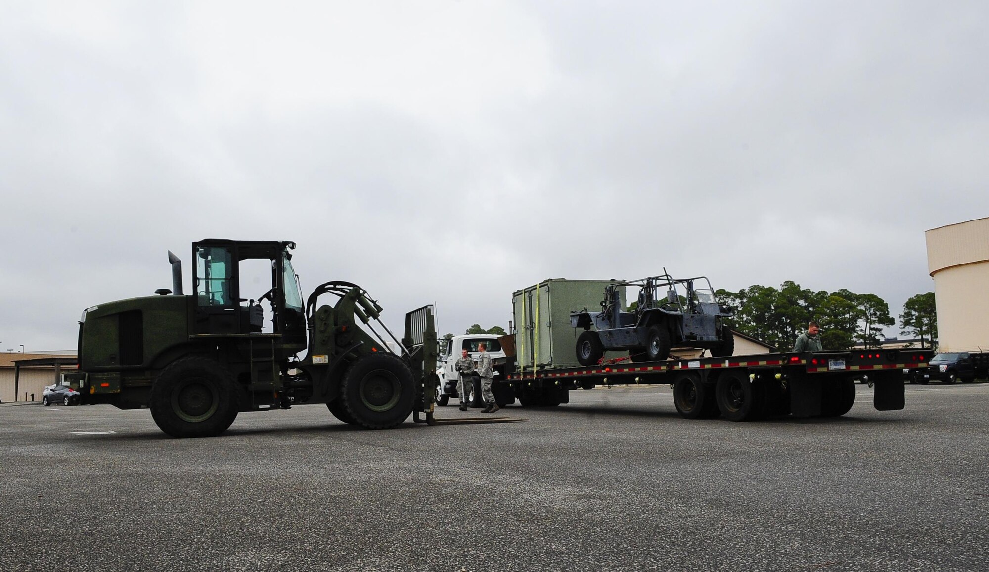 Vehicle operations airmen, from the 1st Special Operations Logistics Readiness Squadron, finish loading a trailer with equipment at Hurlburt Field, Fla., Feb 24, 2015. Vehicle Operations Flight provides transportation services on demand for Hurlburt Field to include Distinguished Visitor support, base taxi, flight line operations and cargo pick-up and delivery services, and government driver's license issue. (U.S. Air Force photo/Airman 1st Class Andrea Posey)