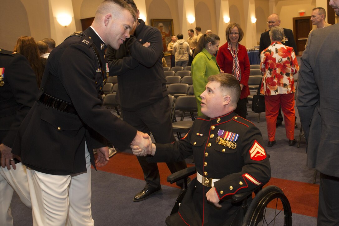 Capt. John Auer, Headquarters and Service Company Commander, congratulates Cpl. Mark Fidler (Ret.) after Fidler's retirement ceremony in Crawford Hall, Marine Barracks Washington, D.C. March 13, 2015. (U.S. Marine Corps photo by Lance Cpl. Christian J. Varney/Released)