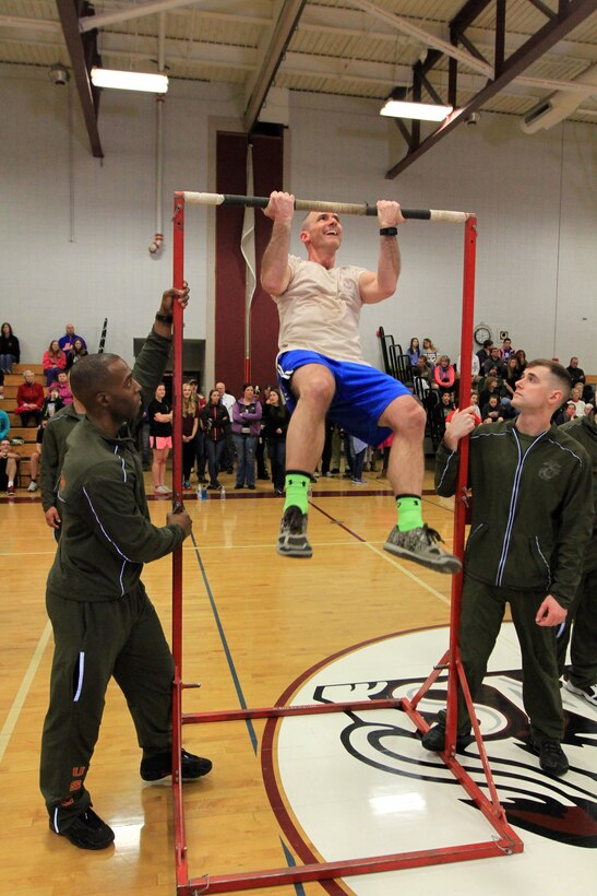 Marines encourage a participant during the 5th Annual Sgt. Josh Desforges Fitness Challenge’s culminating event at Ludlow High School, on March 12. Every participant in the event who lasted the full hour, competed in a pullup challenge to determine the overall male and female winners. The challenge is used as a means to raise money for a scholarship award fund in Josh’s name. Last year, 20 Ludlow High School students were awarded $1,000. (Official Marine Corps photo by Staff Sgt. Richard Blumenstein).