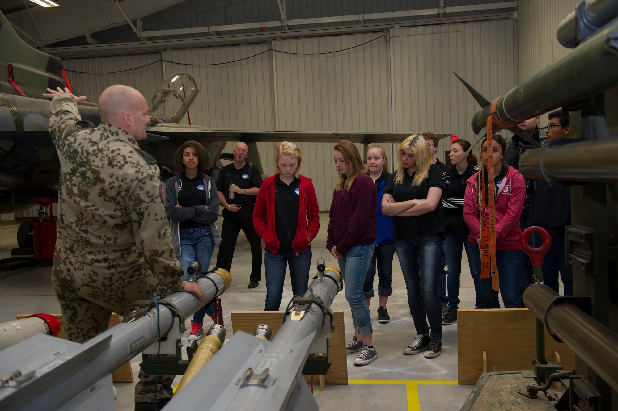 German Air Force Master Sgt. Sebastian Becker, GAF Maintenance and Weapons Squadron, describes weapons specifications to Junior Leadership Otero members. The students were also given the opportunity to sit in the cockpit of a German Tornado bomber. (U.S. Air Force photo by Airman 1st Class Aaron Montoya/RELEASED)
