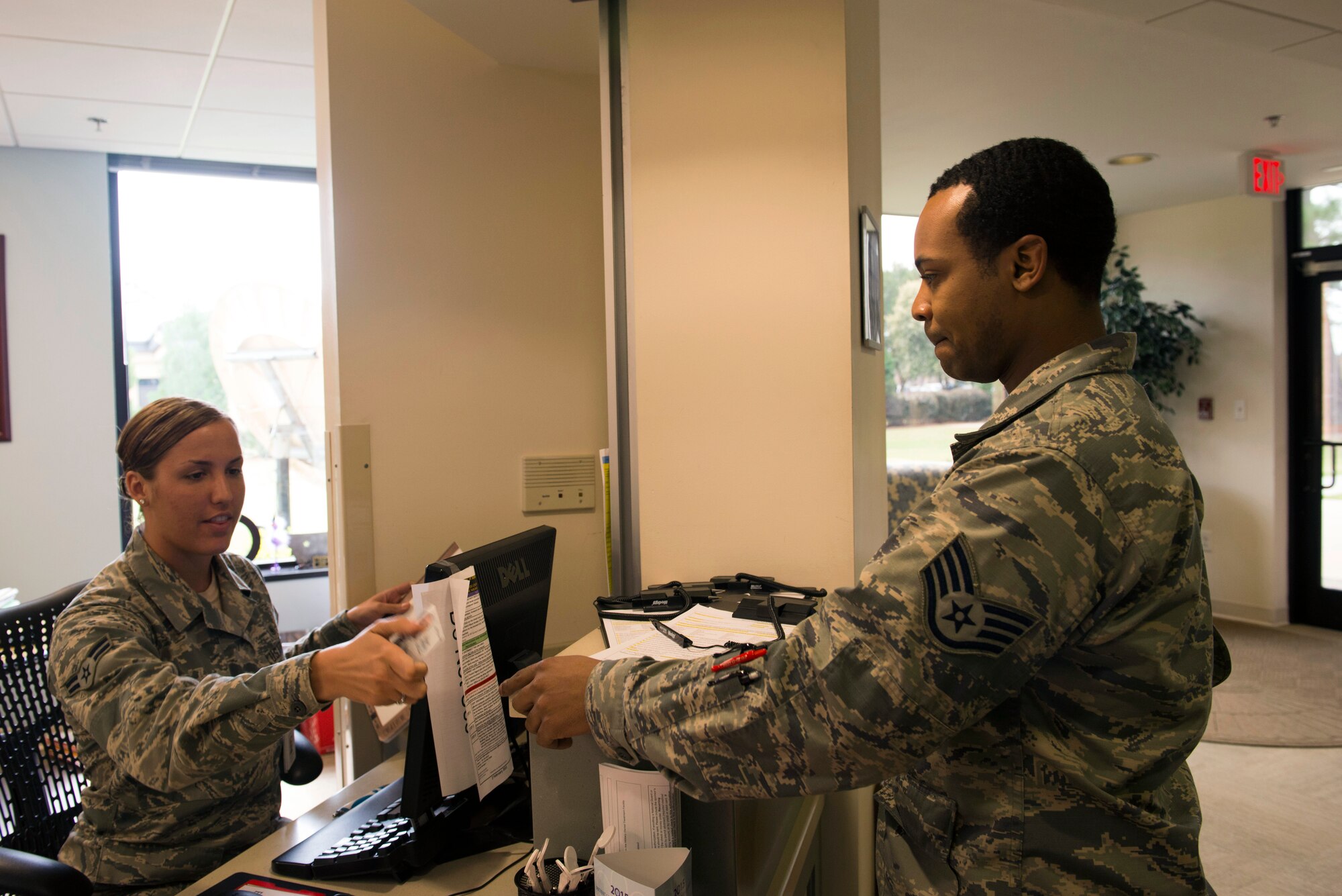 U.S. Air Force Airman 1st Class Paige Ehrlich, left, 23d Aerospace Medicine Squadron dental assistant, checks in a patient for treatment March 12, 2015, at Moody Air Force Base, Ga. The dental clinic participated in Patient Safety Week March 9-13 by increasing their patient verification procedures during processing. (U.S. Air Force photo by Airman 1st Class Dillian Bamman/Released)