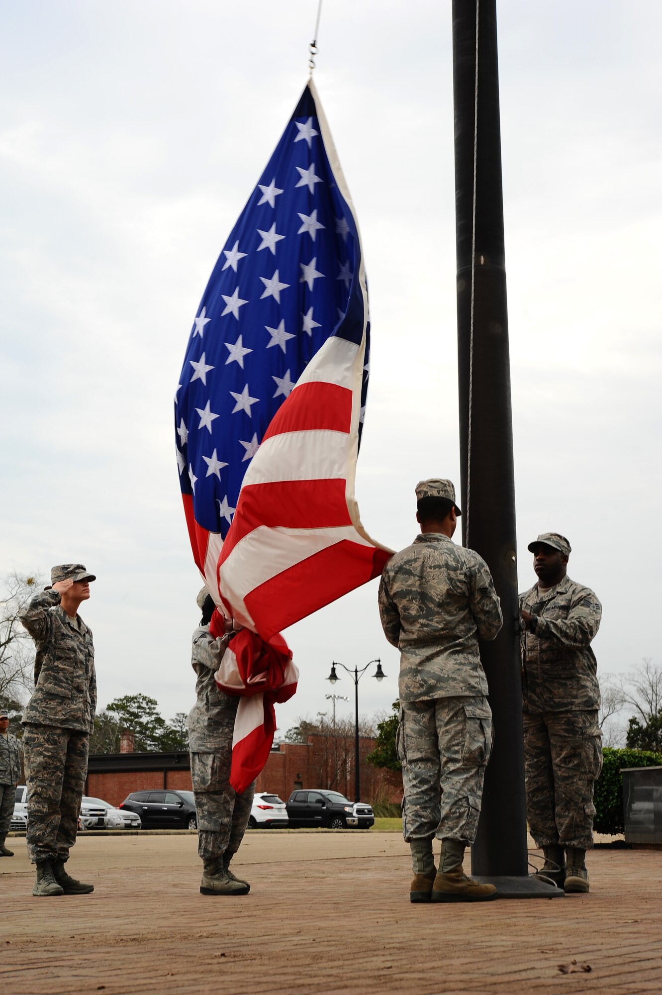 Members of Airman Leadership School Class 15-3 lower the American flag during a retreat ceremony March 12 at the flag pole in the Richard “Gene” Smith Plaza on Columbus Air Force Base. The retreat ceremony encompasses decades of Air Force history and American pride and is performed at the end of the duty day. (U.S. Air Force Photo/ Airman John Day)