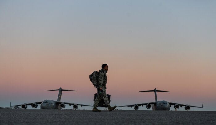 U.S. Air Force Airman 1st Class Andrew-John Thong, 437th Aircraft Maintenance Squadron dedicated crew chief, walks on the flight line to a C-17 Globemaster III at Charleston Air Force Base - Air Base, Jan. 27, 2015. The 437th Aircraft Maintenance Squadron is composed of nearly 1,000 combat-ready maintainers and support personnel, comprised of Active Duty, Civilian, and Air Reserve Technician components. They inspect, service, and maintain the assigned C-17 aircraft at Joint Base Charleston. These maintainers enable aircraft to perform assigned global airlift missions ranging from combat support operations and humanitarian relief to aeromedical evacuations. (U.S. Air Force photo by Senior Airman Daniel Hughes/Not Reviewed)