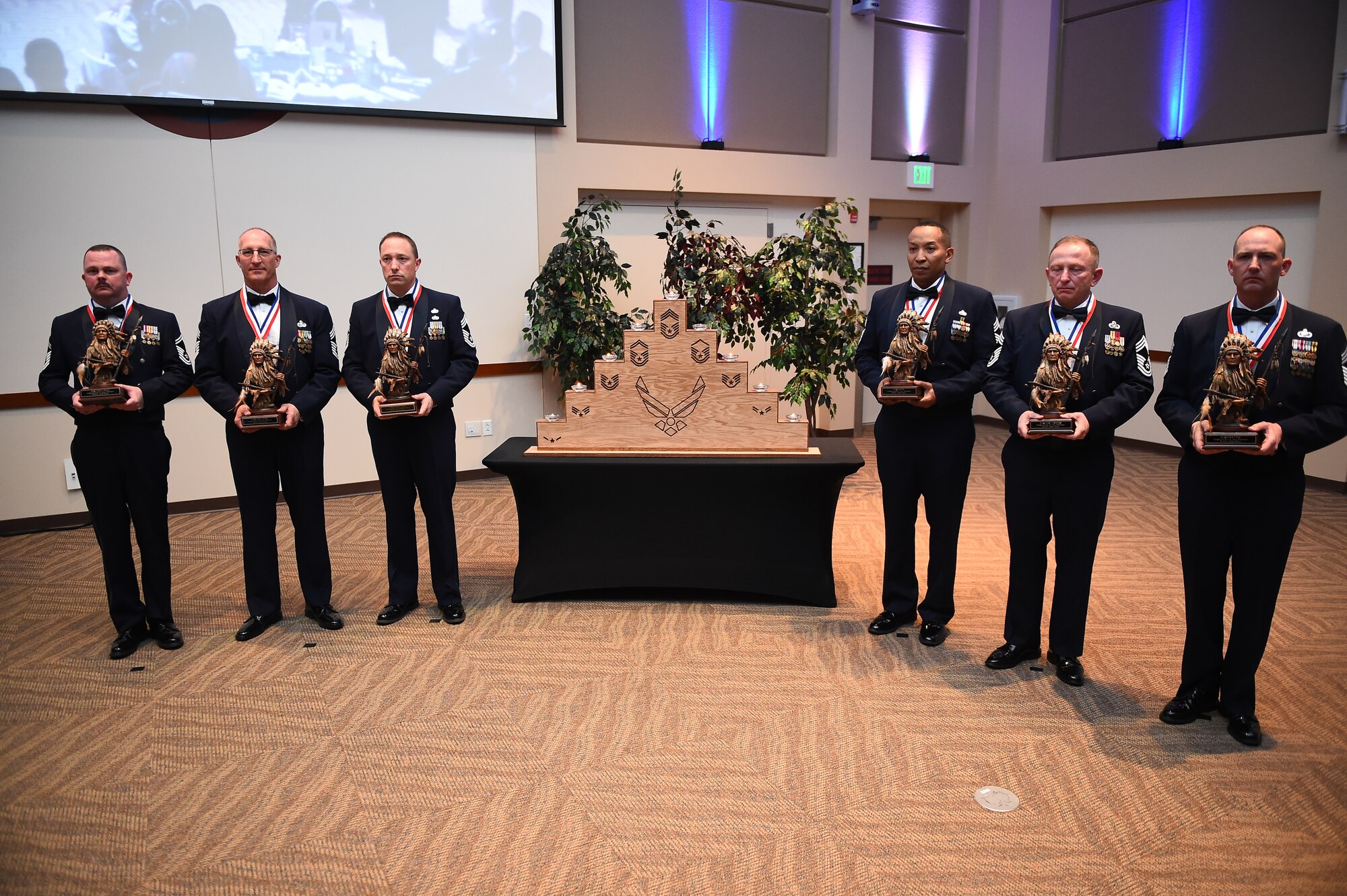 Team Buckley’s newest chief master sergeants stand holding statues representing the inductees’ positions as the top enlisted rank during the chief master sergeant induction ceremony March 12, 2015, at the Leadership Development Center on Buckley Air Force Base, Colo. The ceremony marked six chief master sergeants and chief master sergeant selects joining the top 1 percent of the enlisted Air Force.  The chiefs inducted were Chief Master Sgt. Shane Enos, 460th Comptroller Squadron; Chief Master Sgt. Halbert Frank, 140th Operations Group; Chief Master Sgt. Sebastien Garcia, 140th Force Support Squadron; Chief Master Sgt. Wade Herzog, 233rd Space Group; Chief Master Sgt. James Fernandez, 140th Wing; and Senior Master Sgt. Wesley Seschuler, 566th Intelligence Squadron. (U.S. Air Force photo by Senior Airman Riley Johnson/Released)