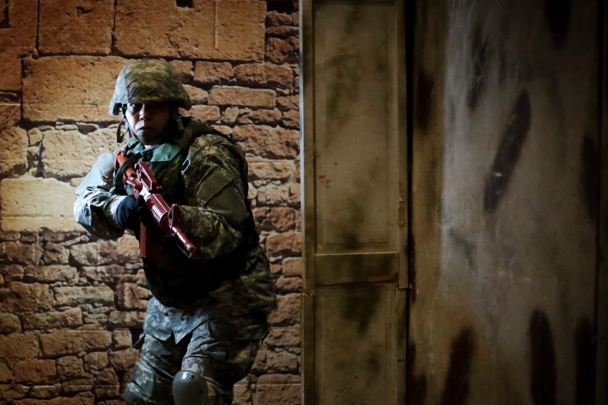 U.S. Army Capt. Joannie Floyd exits a doorway during a Modern Army Combatives Program (MACP) training scenario at the New Jersey National Guard Training and Training Technology Battle Lab at Joint Base McGuire-Dix-Lakehurst, N.J., March 11, 2015. The Battle Lab features numerous combat simulators, as well as an indoor urban area for ground combat training. Fields is assigned to the 1-314th Infantry Battalion. (U.S. Air National Guard photo by Tech. Sgt. Matt Hecht/Released)
