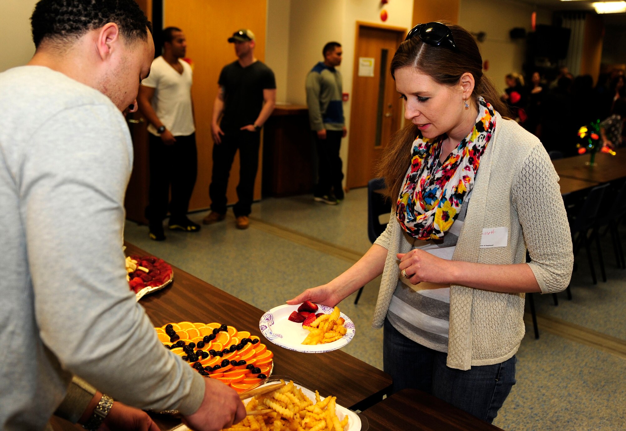U.S. Air Force Tech Sgt. Alton Lee, left, 100th Maintenance Squadron NCO in charge of Nondestructive Inspection from Virginia Beach, Va., serves dinner to a spouse of a deployed Airman at the monthly Hearts Apart event March 12, 2015, at the chapel on RAF Mildenhall, England. A Hearts Apart dinner is an opportunity for spouses and family members of deployed Airmen to gather and show support for one another. (U.S. Air Force photo/Staff Sgt. Krystie Martinez/Released)