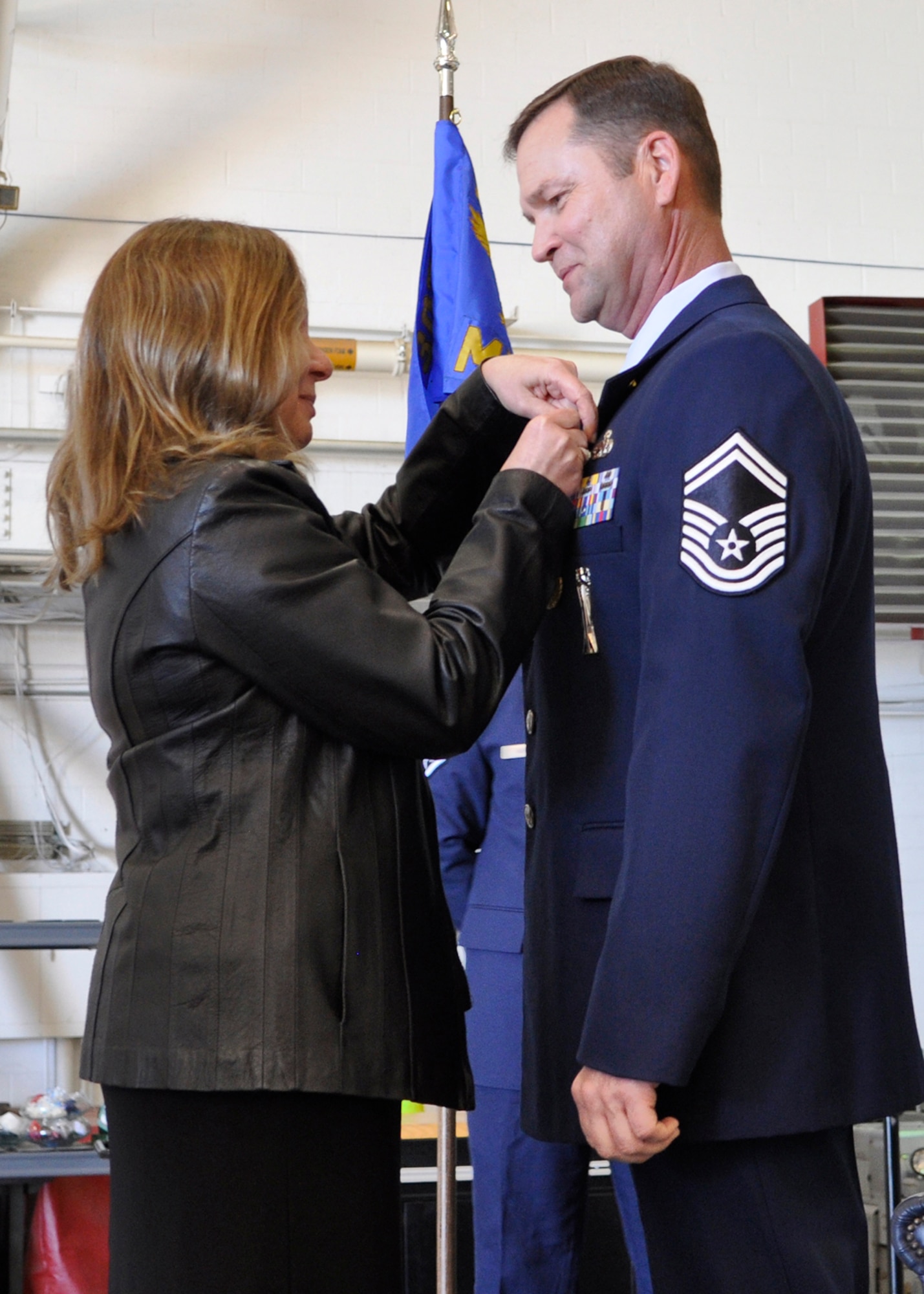 Karen Goff pins the Air Force retirement pin on her husband, U.S. Air Force Senior Master Sgt. Victor Goff during his retirement ceremony, Mar. 7, 2015, Barksdale Air Force Base, La. Goff retired with over 30 years of military service from the 307th Maintenance Squadron. (U.S. Air Force photo by 2nd Lieutenant Monique Roux/Released)