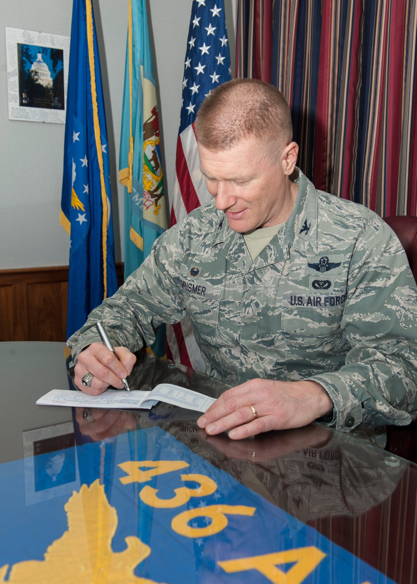 Col. Michael Grismer, 436th Airlift Wing commander, signs a donation form for the Air Force Assistance Fund Mar. 13, 2015, at Dover Air Force Base, Del. The Air Force Assistance Fund (AFAF) is an annual effort to raise funds for the charitable affiliates that provide support to Air Force families in need (active duty, retirees, reservists, guard and our dependents, including surviving spouses). (U.S. Air Force photo/Airman 1st Class Zachary Cacicia)