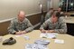 Col. Mark Slocum, 4th Fighter Wing commander, and Chief Master Sgt. Jeffrey Craver, 4th FW command chief, fill out donation cards for the 2015 Air Force Assistance Fund, March 4, 2015, at Seymour Johnson Air Force Base, North Carolina. The AFAF raises funds for a variety of programs that provide support ranging from financial assistance to care for military widows. (U.S. Air Force photo/Airman Shawna L. Keyes)