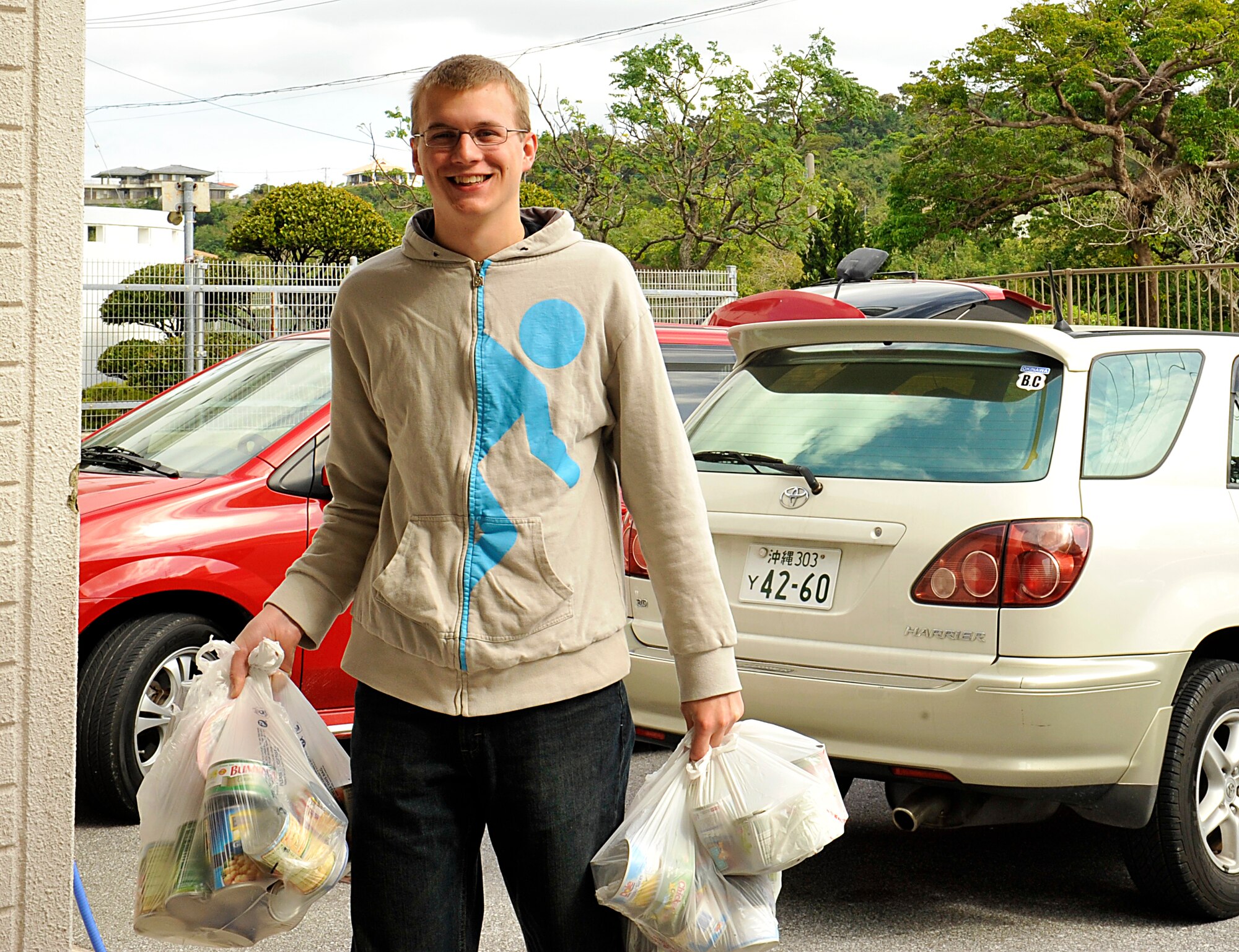 U.S. Air Force Airman 1st Class Logan Schlueter, 18th Logistics readiness Squadron material management apprentice journeyman, carries donations into the Chatan Town Welfare Center, Japan, March 11, 2015. The welfare food drive was held to foster positive relationships and interactions in Kadena’s community and distribute to families in need in the Okinawan community. (U.S. Air Force photo by Naoto Anazawa)