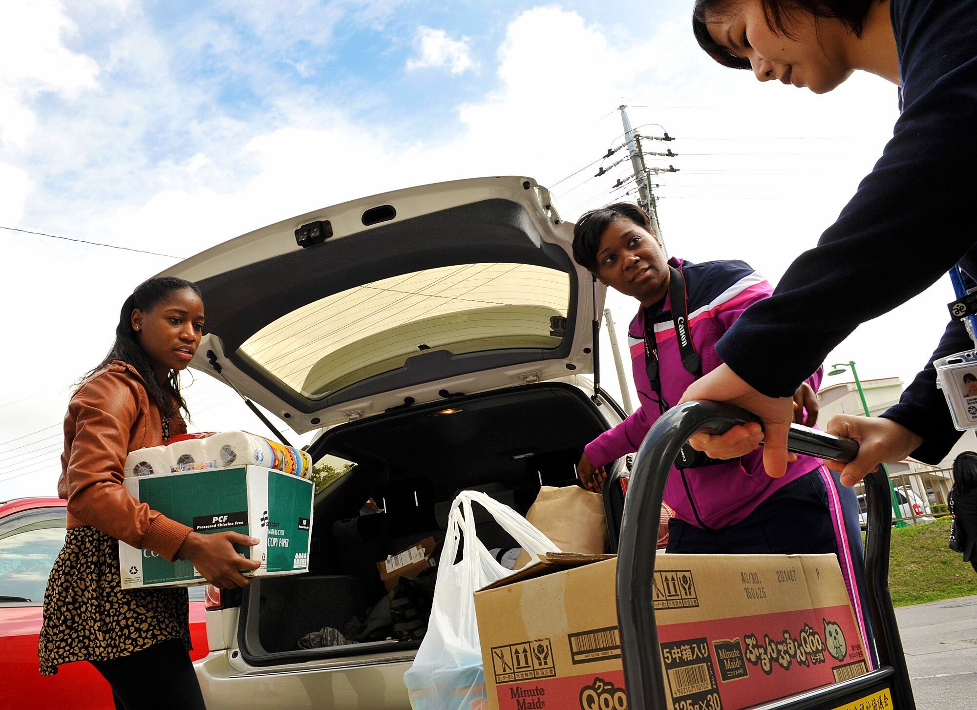 Members from the Kadena Air Base Top 3 program unload a vehicle full of donations for Chatan Town Welfare Center, Japan, March 11, 2015. The welfare drive is an annual event led by the Okinawa Outreach Committee. Members from the Kadena Air Base Top 3 program donated approximately 600-pounds to the Chatan Town Welfare Center. (U.S. Air Force photo by Naoto Anazawa)