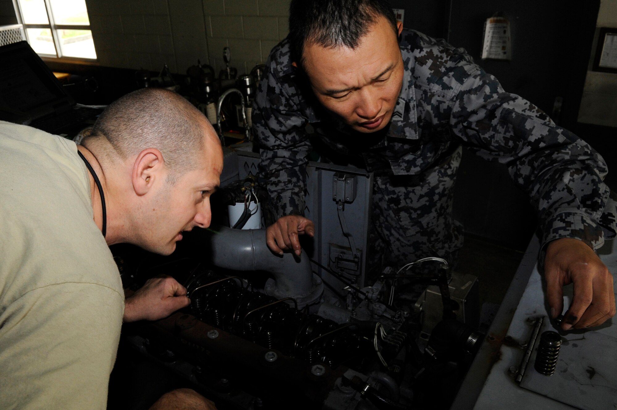 Japan Air Self-Defense Force Tech. Sgt. Daisuke Mitsunaga (right), Iwo To Air Base Group Aerospace Ground Equipment craftsman, and U.S. Air Force Tech. Sgt. Jason Blocker, 18th AGE craftsman, remove parts from a generator during an NCO exchange on Kadena Air Base, Japan, March 5, 2015. The NCOs spent more than a week working together and finding similarities with each other’s job. (U.S. Air Force photo by Staff Sgt. Marcus Morris)
