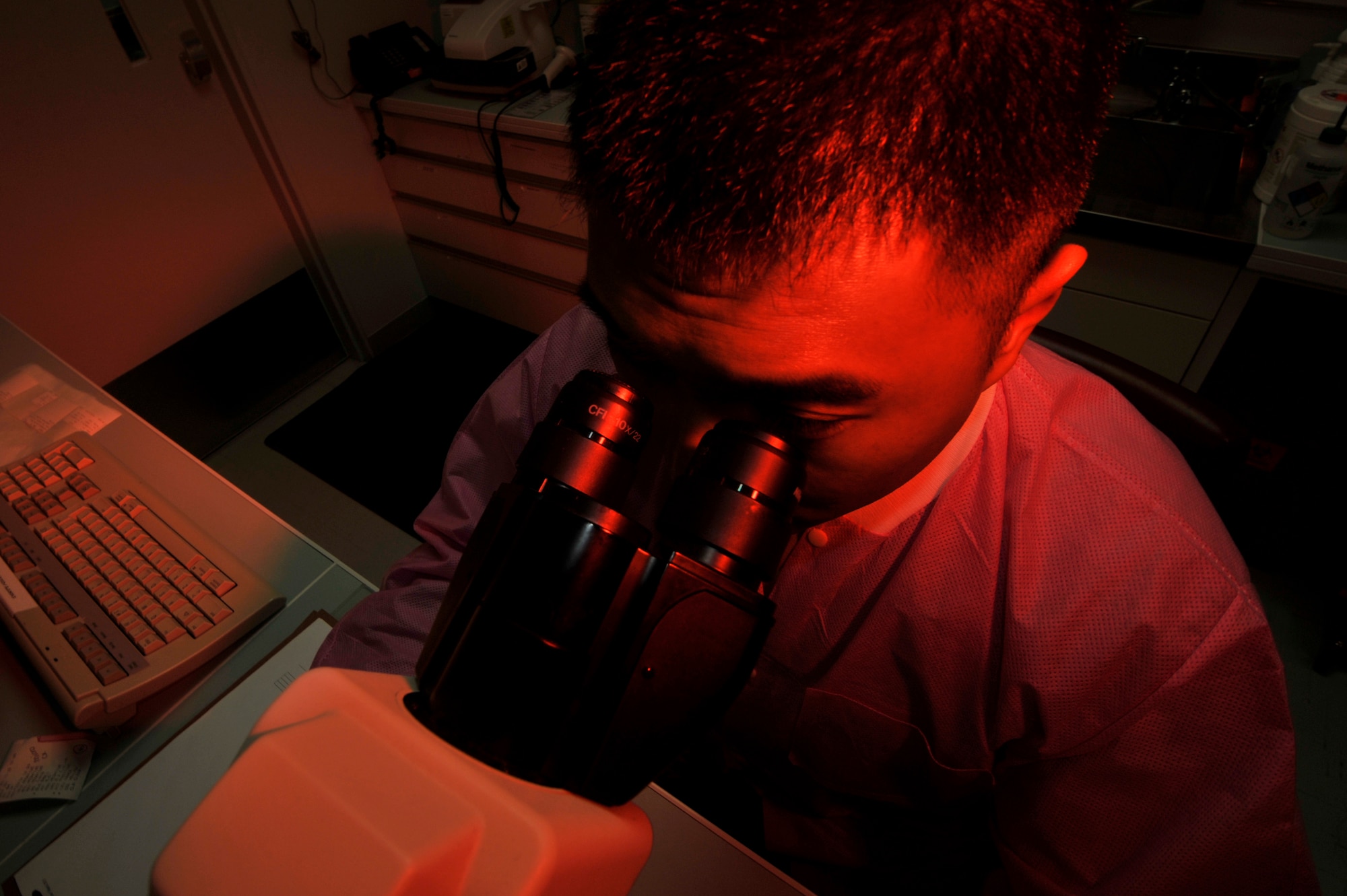 U.S. Air Force Staff Sgt. John-Andre Obedoza, 35th Medial Support Squadron NCO in charge of shipping and urinalysis, manually checks a urinalysis sample for any abnormalities at Misawa Air Base, Japan, March 11, 2015. Results of a urinalysis are completed utilizing a urine chemistry analyzer; however, when a discrepancy is identified, it is analyzed manually for confirmation. (U.S. Air Force photo by Senior Airman Jose L. Hernandez-Domitilo/Released)