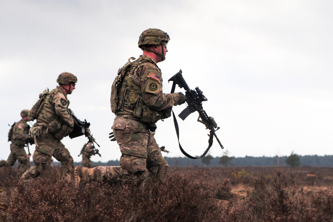 U.S. soldiers move tactically to engage a simulated enemy target during a combined live-fire exercise with Lithuanian soldiers on Pabrade training area, Lithuania, March 3, 2015.