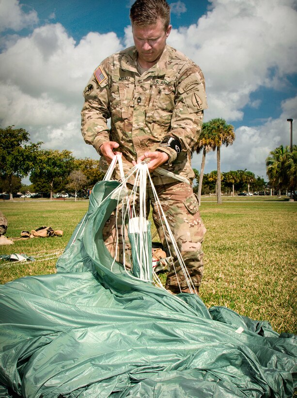 Army Sgt. 1st Class Andrew Mehall adjusts the lines on his parachute after a combat equipment jump demonstration on Homestead Air Reserve Base, Fla., March 4, 2015. Mehall is assigned to the U.S. Army Special Operations Command parachute team, the Black Daggers.