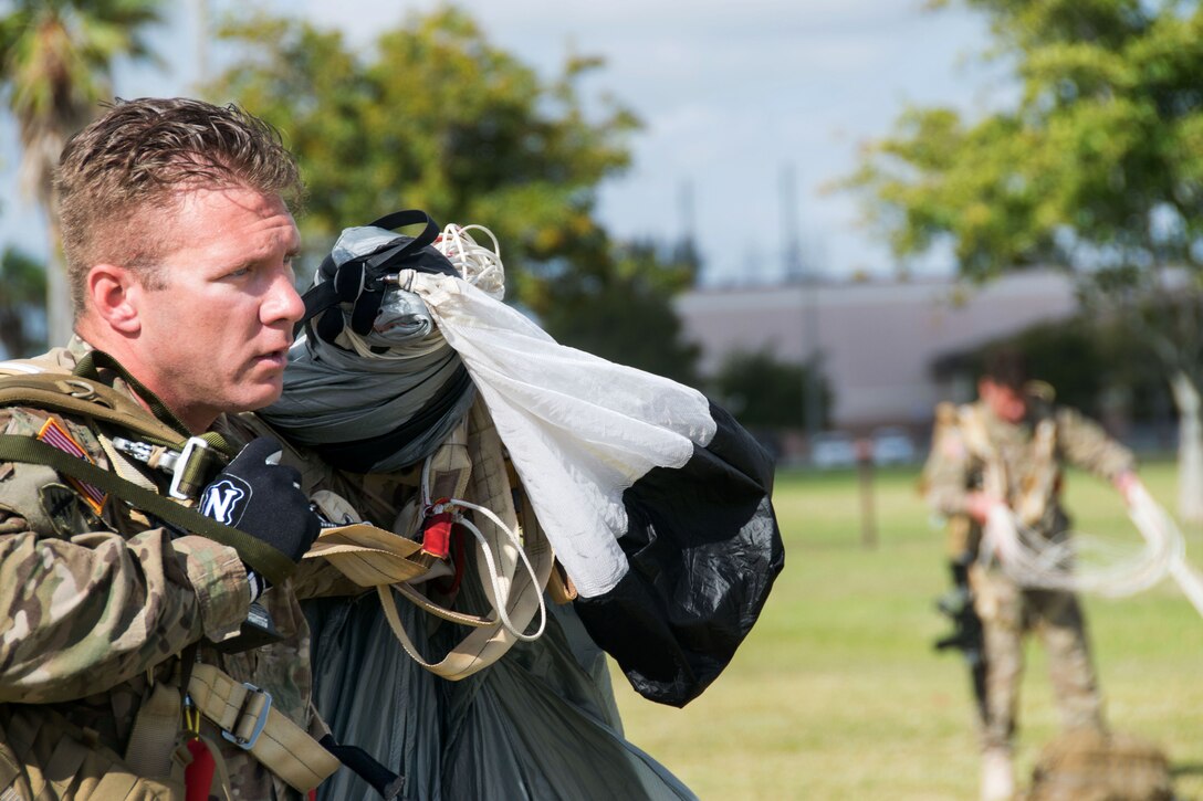 Army Sgt. 1st Class Andrew Mehall gathers his parachute and equipment following a combat equipment jump demonstration on Homestead Air Reserve Base, Fla., March 4, 2015. Mehall is assigned to the U.S. Army Special Operations Command parachute team, the Black Daggers.