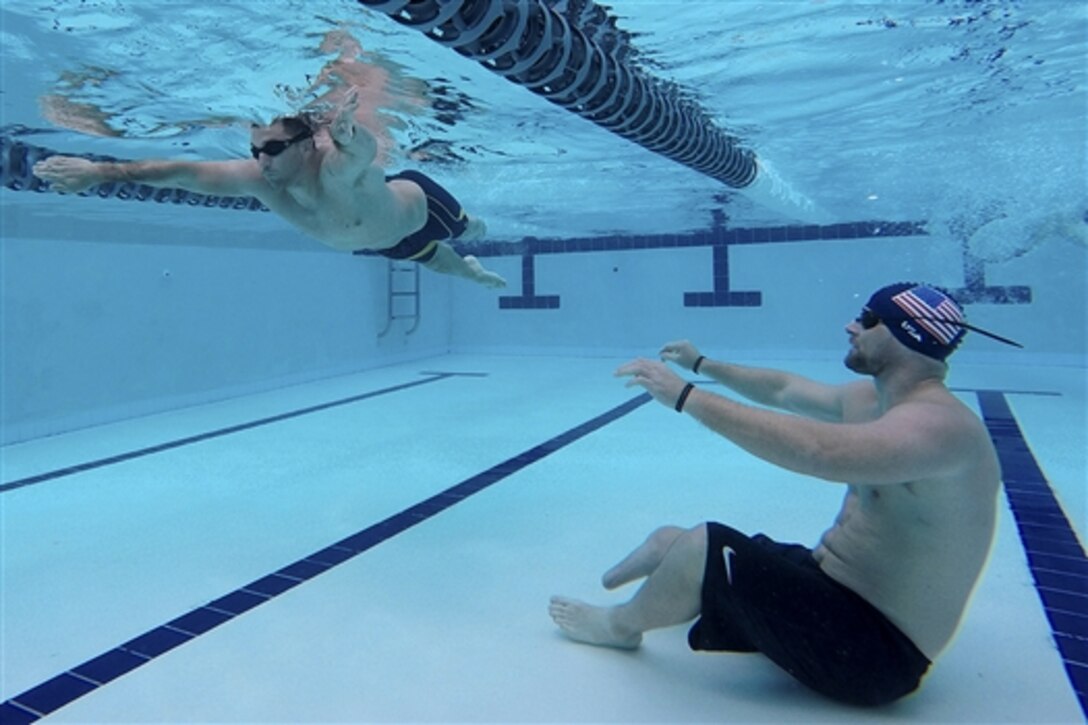 Brett Parks, right, a participant in the Navy Safe Harbor-Wounded Warrior program, observes Redmond Ramos as he participates in Pacific Trials swimming practice on Joint Base Pearl Harbor-Hickam, Hawaii, March 10, 2015.