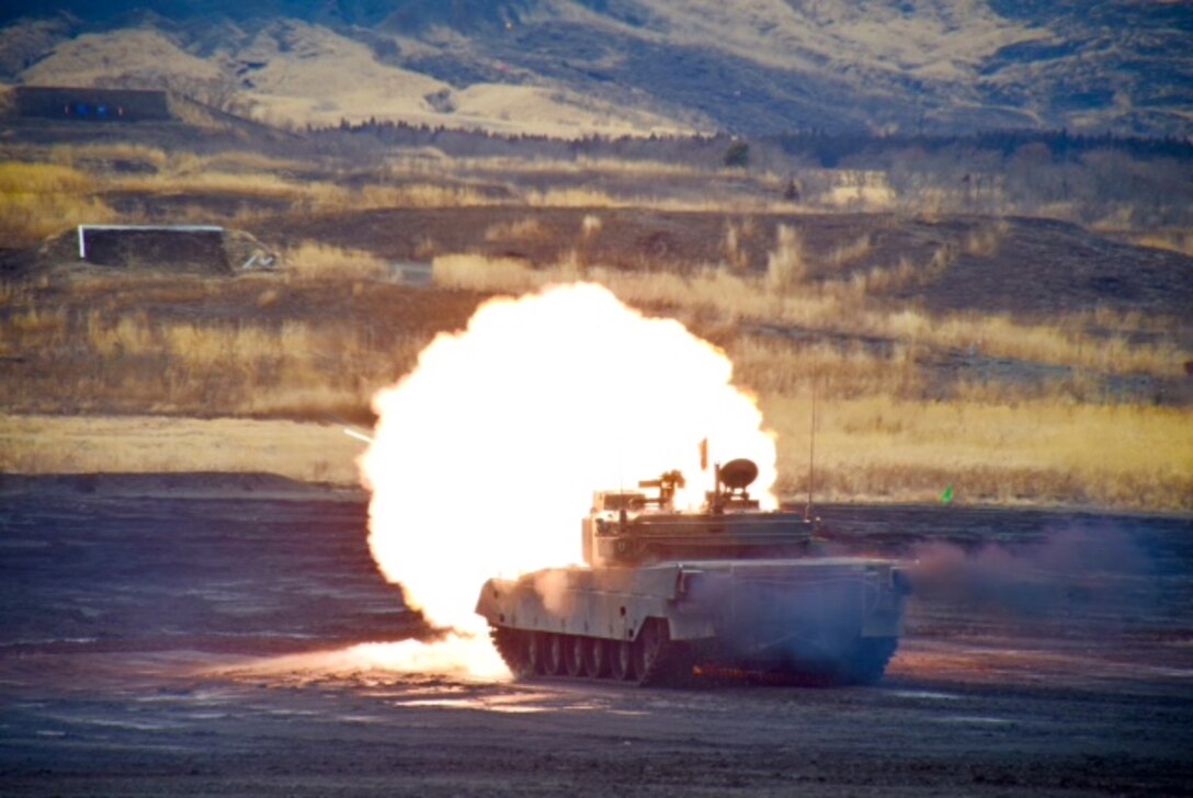 A Type 90 tank fires a round from its main gun at a target downrange in the Eastern Fuji Maneuver Area on March 9, 2015. Several Marines from CATC Camp Fuji observed the tank fire competition that was performed by the JGSDF.