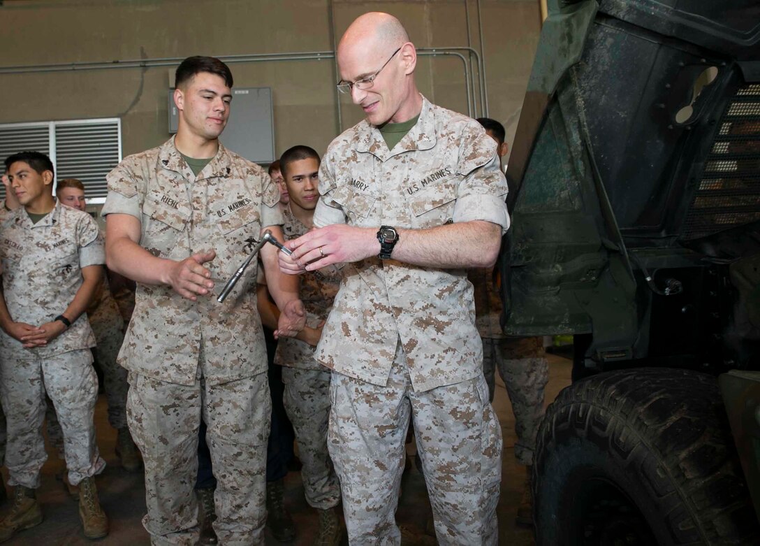 Cpl. John T. Riehl, left, hands Lt. Col. John C. Barry a socket wrench so he can put the last bolt in a Humvee March 13 on Marine Corps Air Station Futenma. The final bolt in the Humvee made Marine Air Control Squadron 4 the only unit in the Marine Corps to be at 100% equipment readiness. MACS-4 has over 140 pieces of equipment they must maintain. Riehl is an automotive organizational mechanic with MACS-4, Marine Air Control Group 18, 1st Marine Aircraft Wing, III Marine Expeditionary Force. Barry is the commanding officer of MACS-4. 